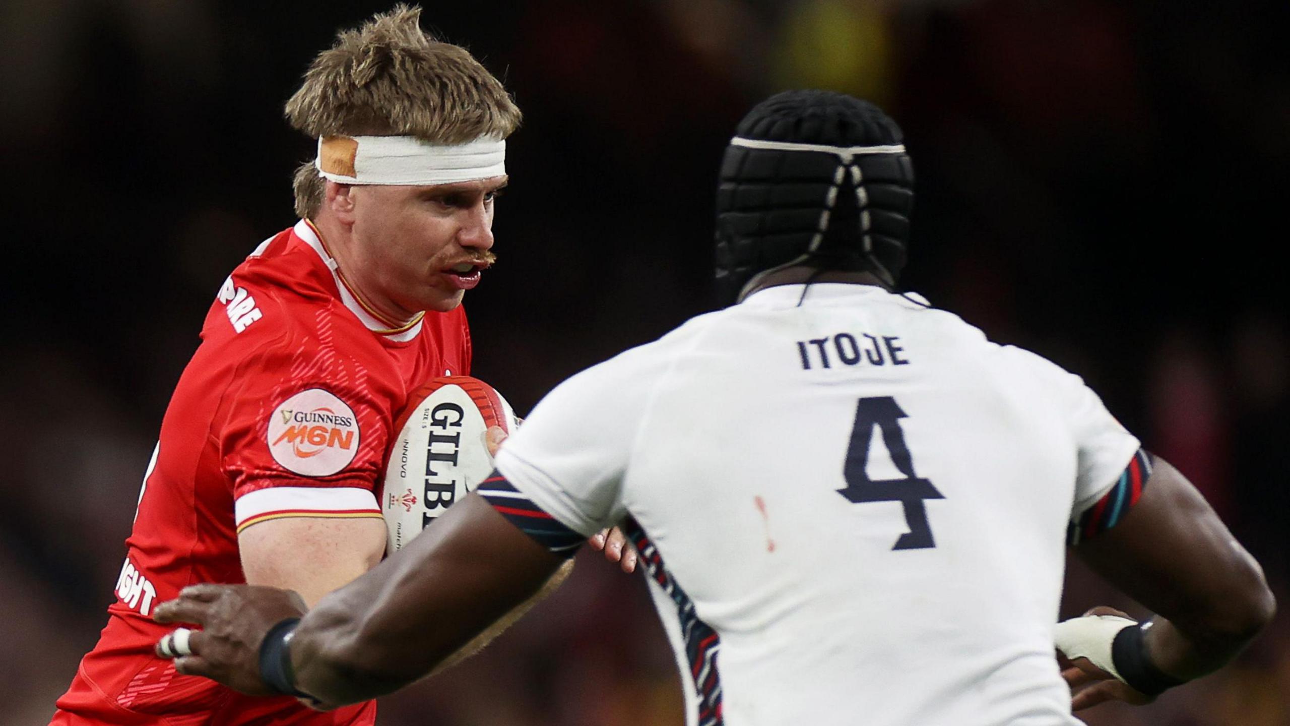 Aaron Wainwright is tackled by England captain Maro Itoje