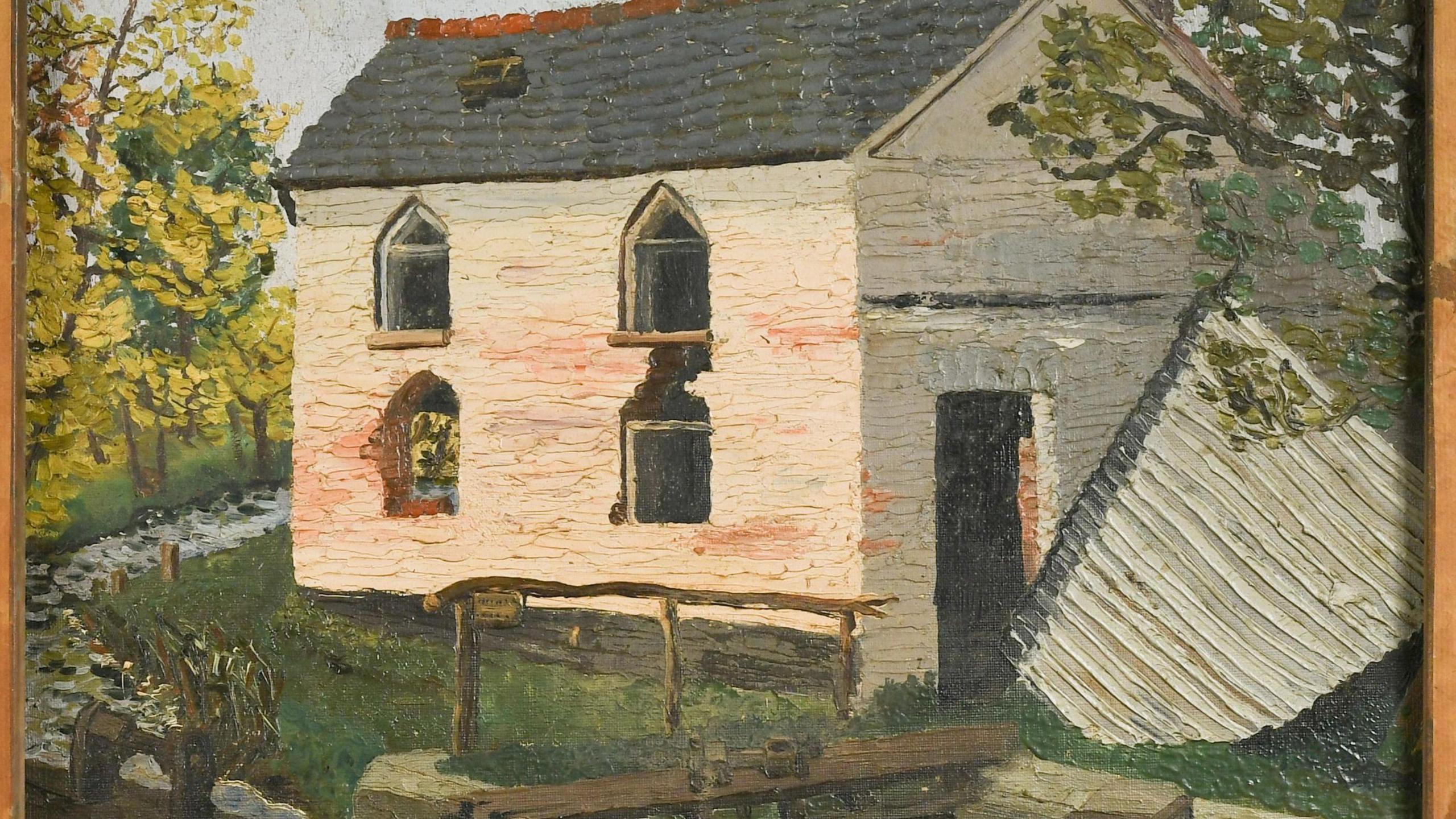 The reverse side of another painting in a wooden frame shows a run down home in the country. It is white, with chipped paint, missing glass in the windows and has a hole in the roof. There are some trees, grass and a little stream around the building.