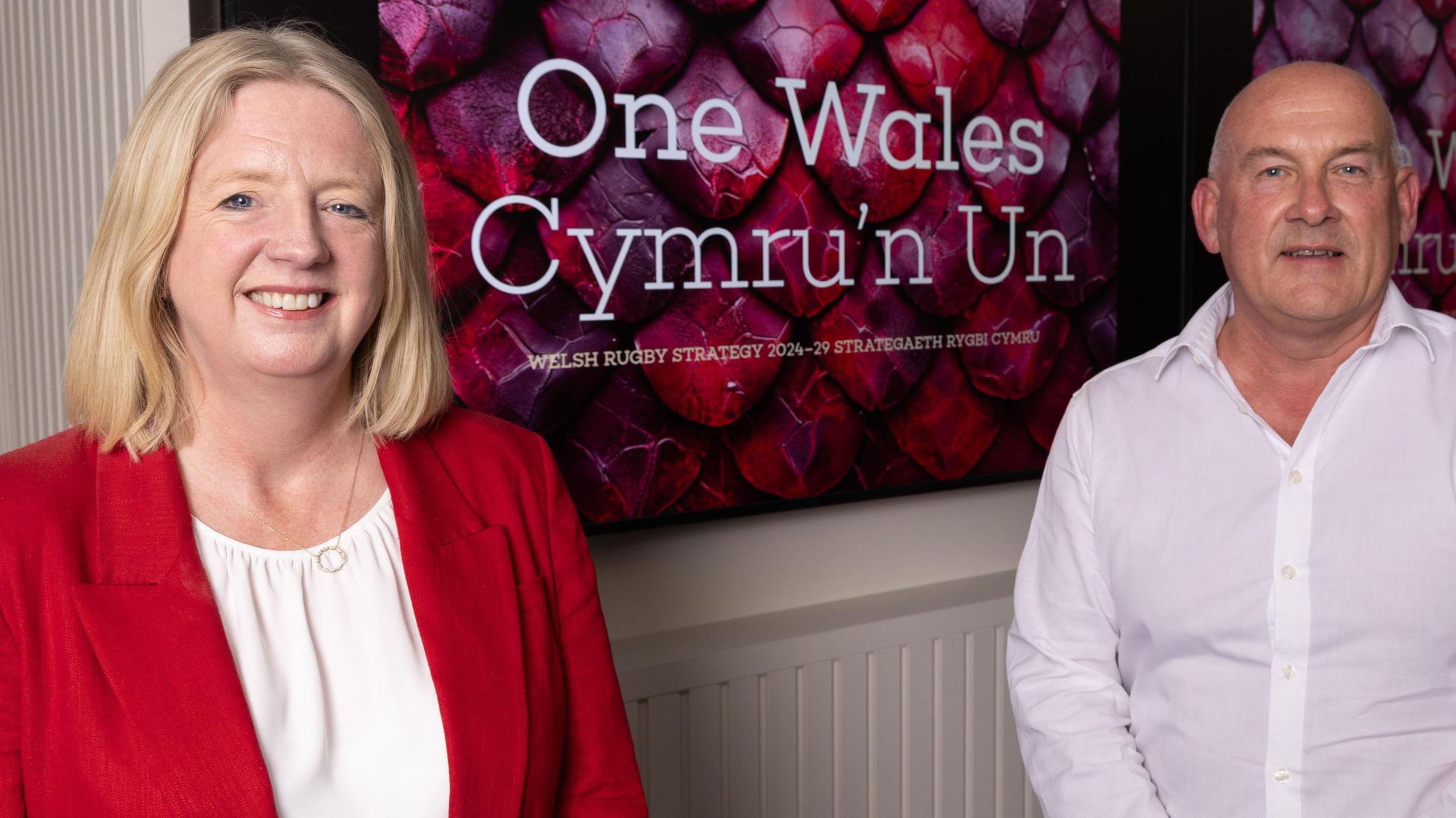 Welsh Rugby Union (WRU) chief executive Abi Tierney (left) standing next to chair Richard Collier-Keywood with a 'One Wales, Cymru'n Un' sign between them
