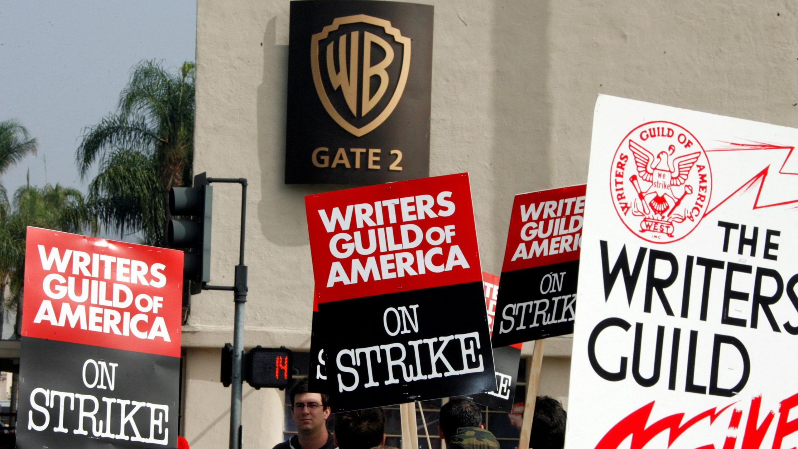 People stand with signs during Hollywood writer strikes 