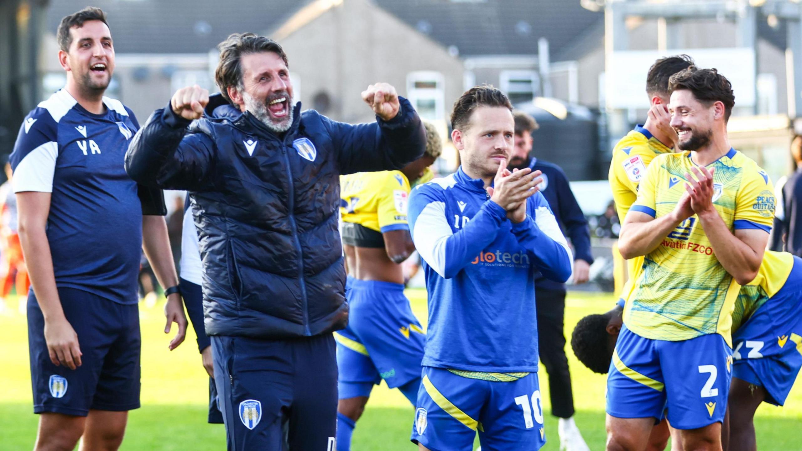 Danny Cowley, with both fists clenched, celebrates Colchester's win at Grimsby in October