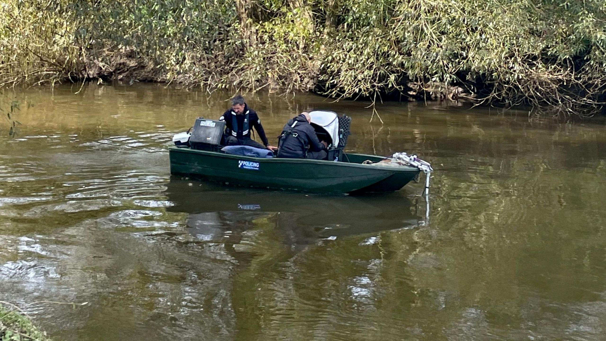 Two police officers in a boat on the River Derwent.