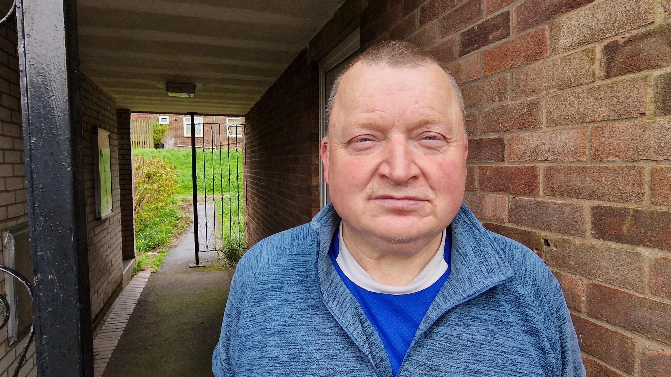 John Waterworth standing in front of the door of his flat 