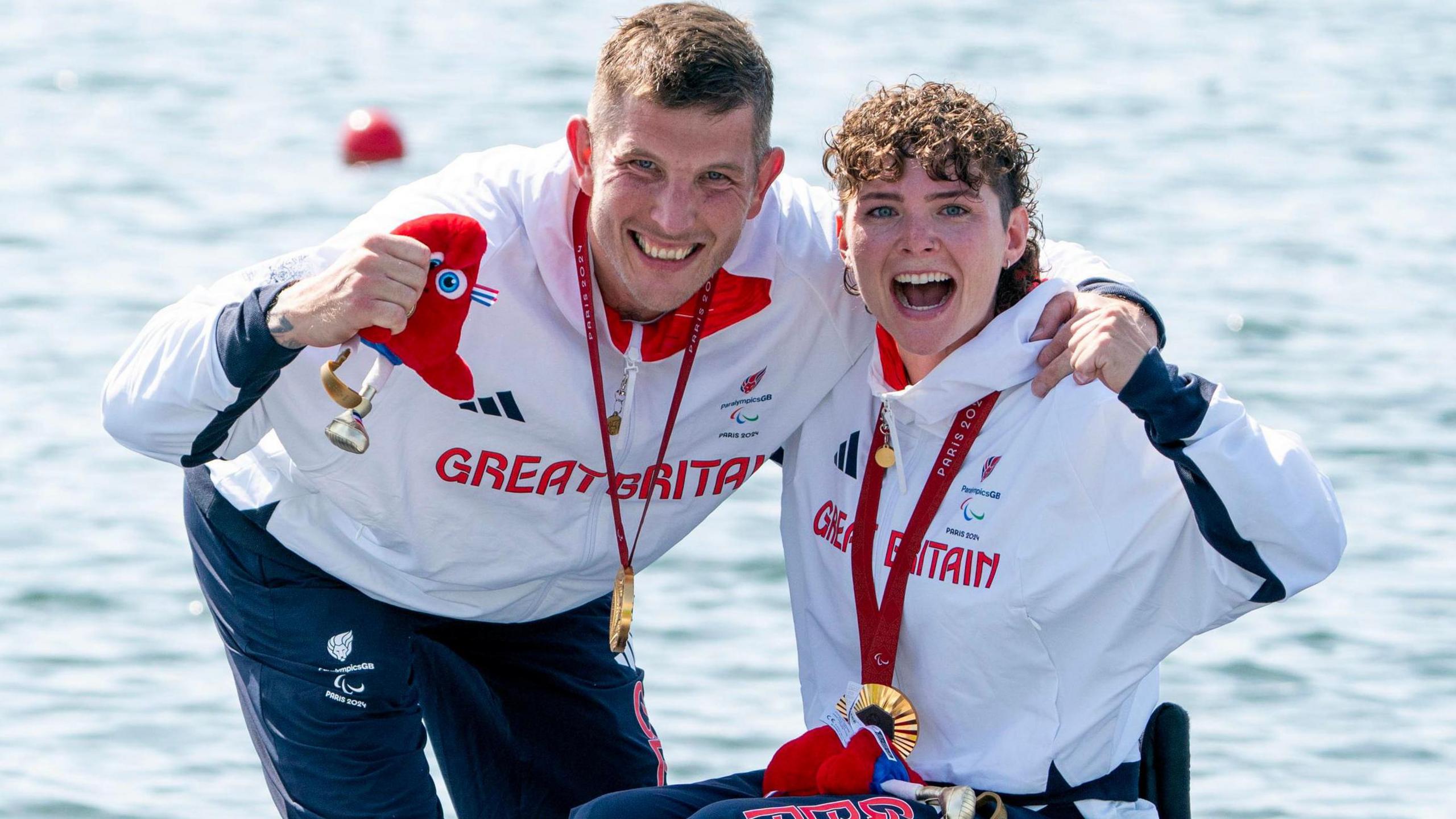 Great Britain's Lauren Rowles (right) and Gregg Stevenson celebrate with their gold medals , wearing white and red Great Britain training kit in front of the Seine