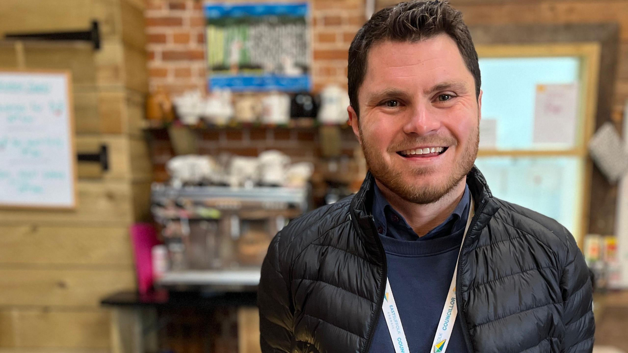 Cllr George King stands in front of the farm café counter