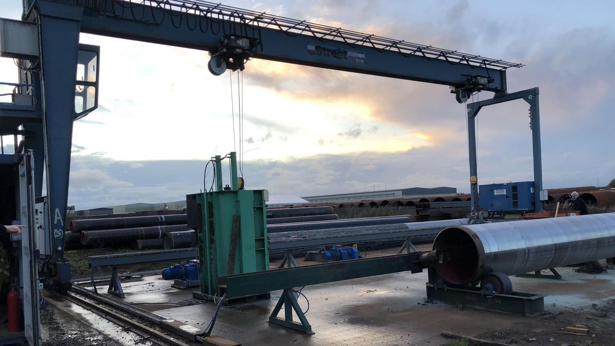 Steel pipes and machinery at an outdoor site