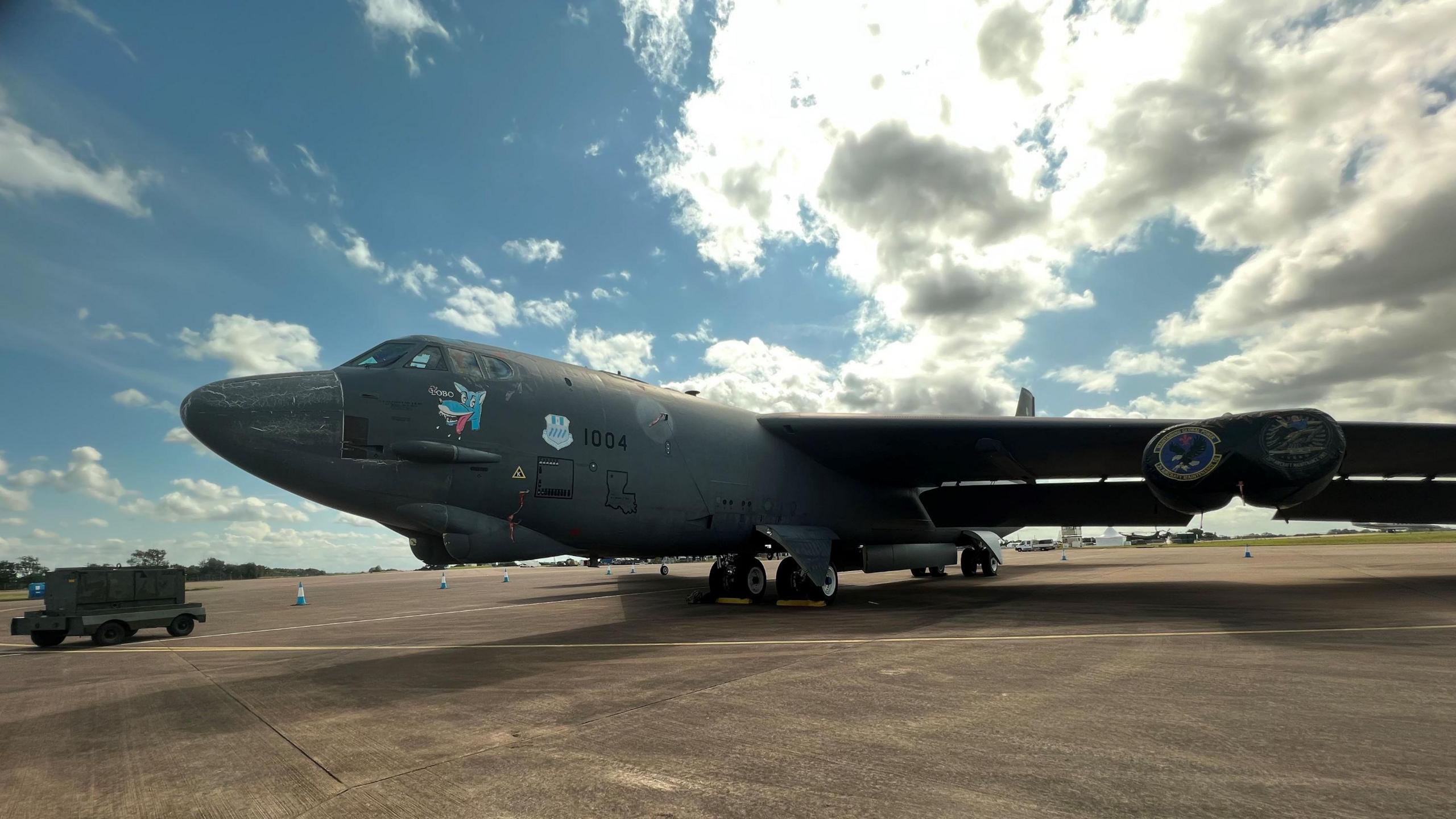 A grey plane on the ground with sunny skies above