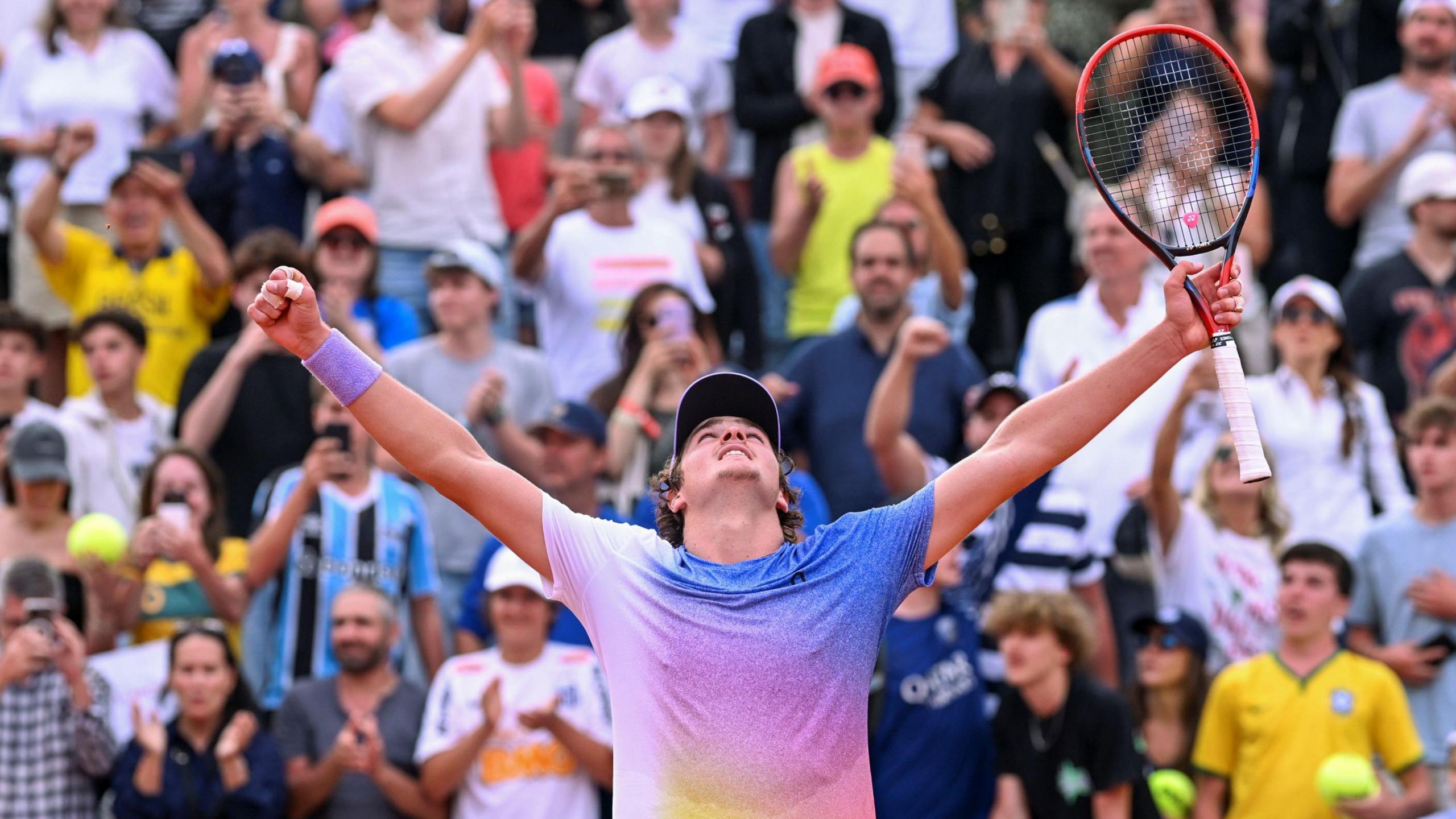 Joao Fonseca celebrates after beating France's Pierre-Hugues Herbert