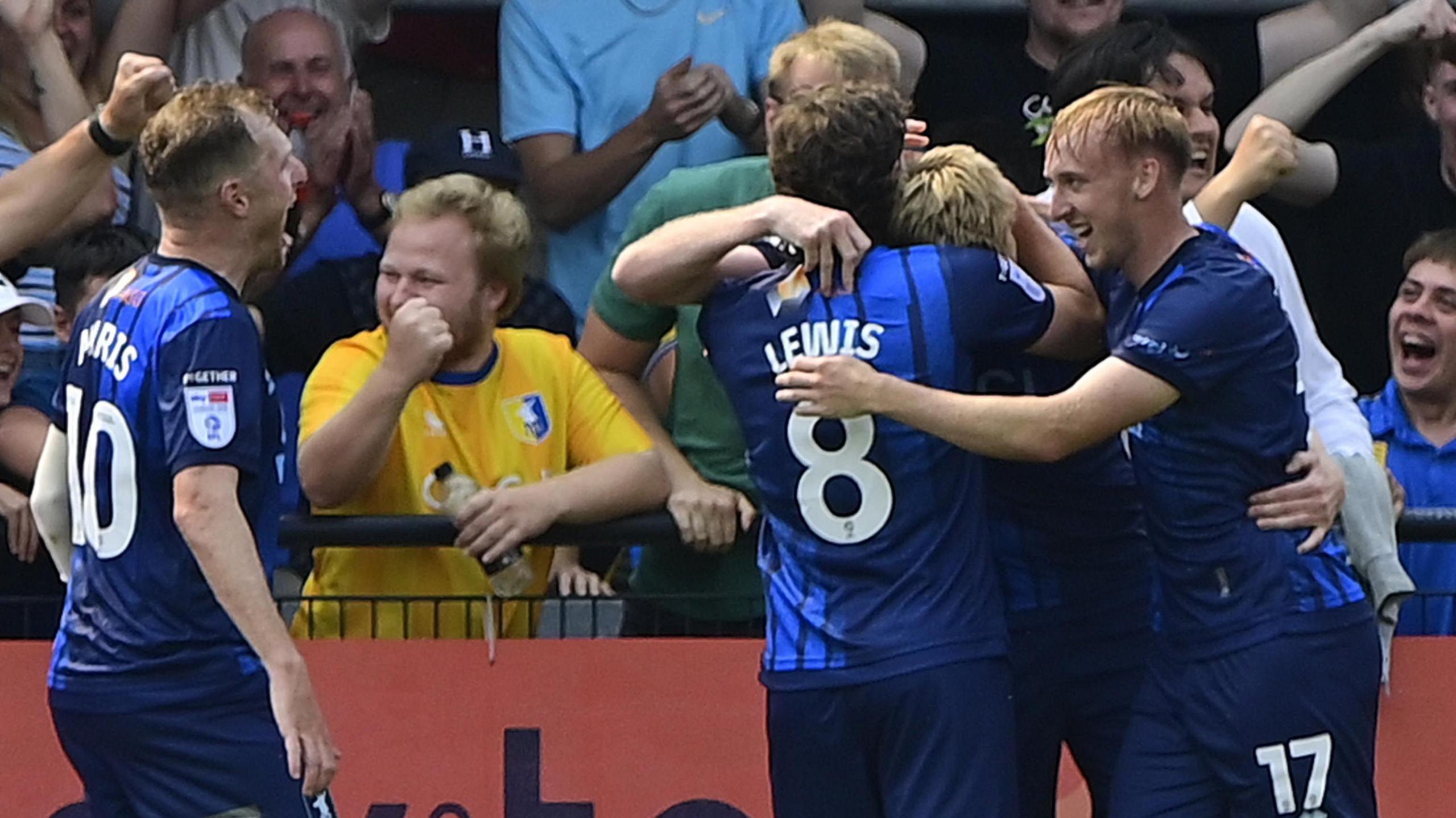 Mansfield players surround Will Evans following his goal against Exeter