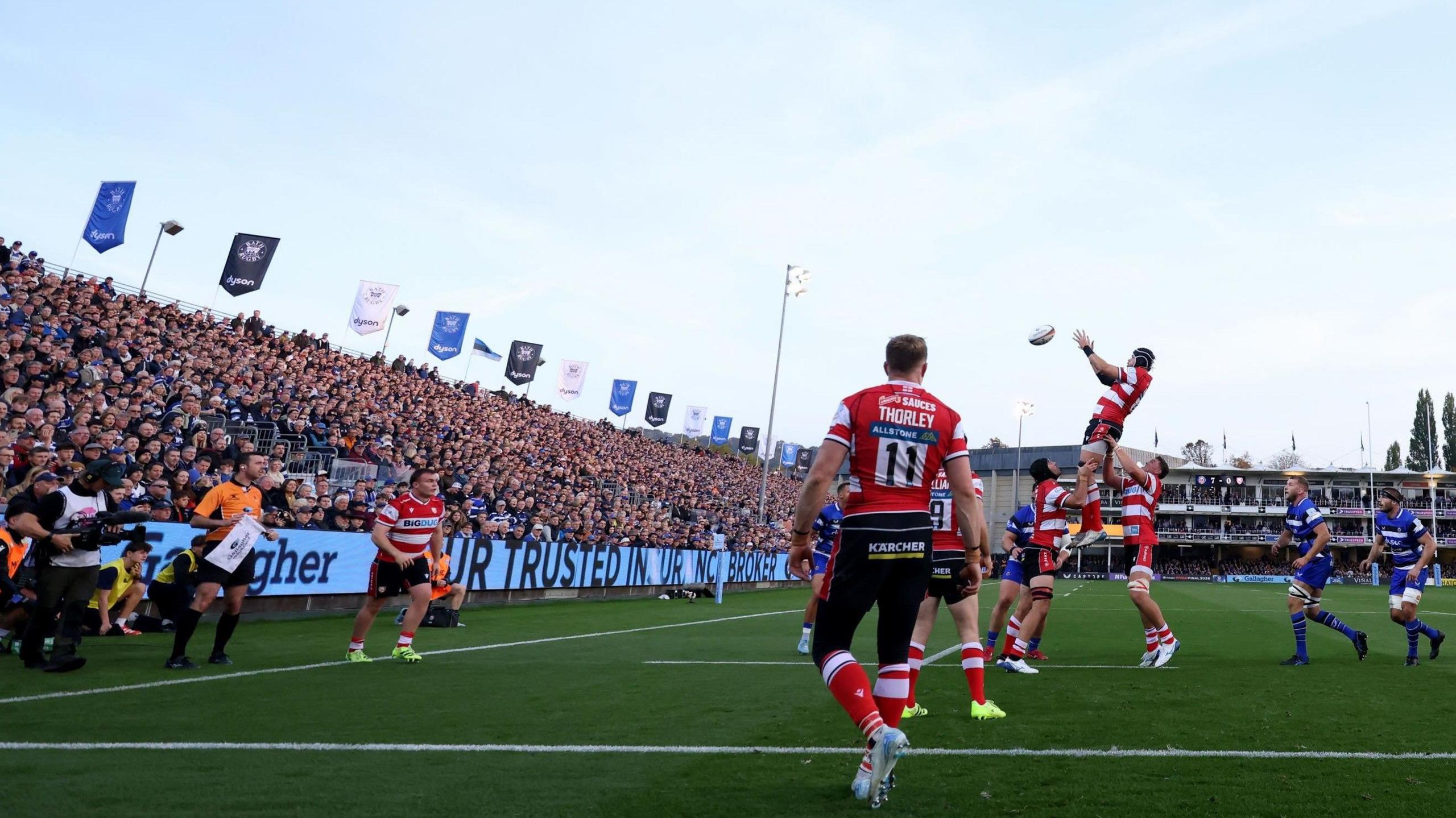 Gloucester players claim a lineout during the match with Bath at the Recreation Ground. In the background is one of the temporary uncovered stands, which is full of fans