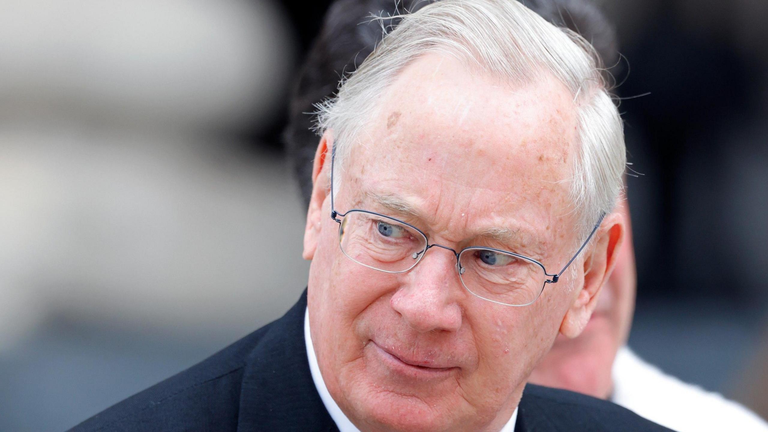 Richard, Duke of Gloucester, wearing a dark suit and a white shirt, at a public event.