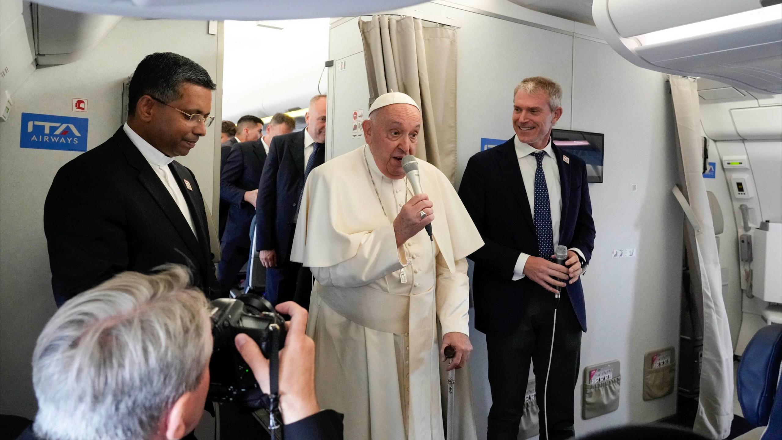 Pope Francis talks to journalists aboard the flight bound for the Indonesian capital, Jakarta