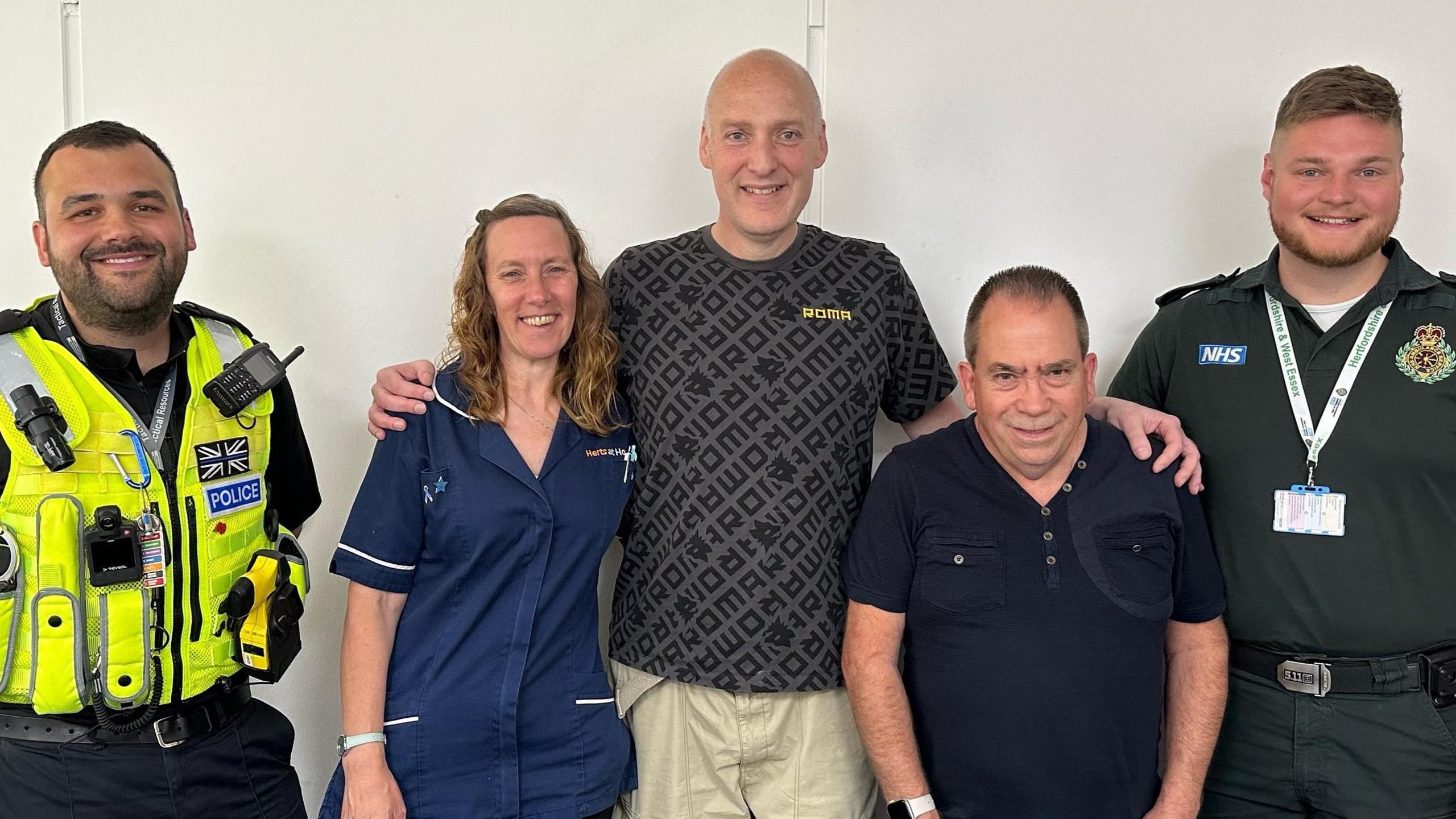 PC Ellis, Claire Leverington, Marco Desider, David Williams and Rob Allmey (from left to right) standing in front of a white wall facing the camera and smiling