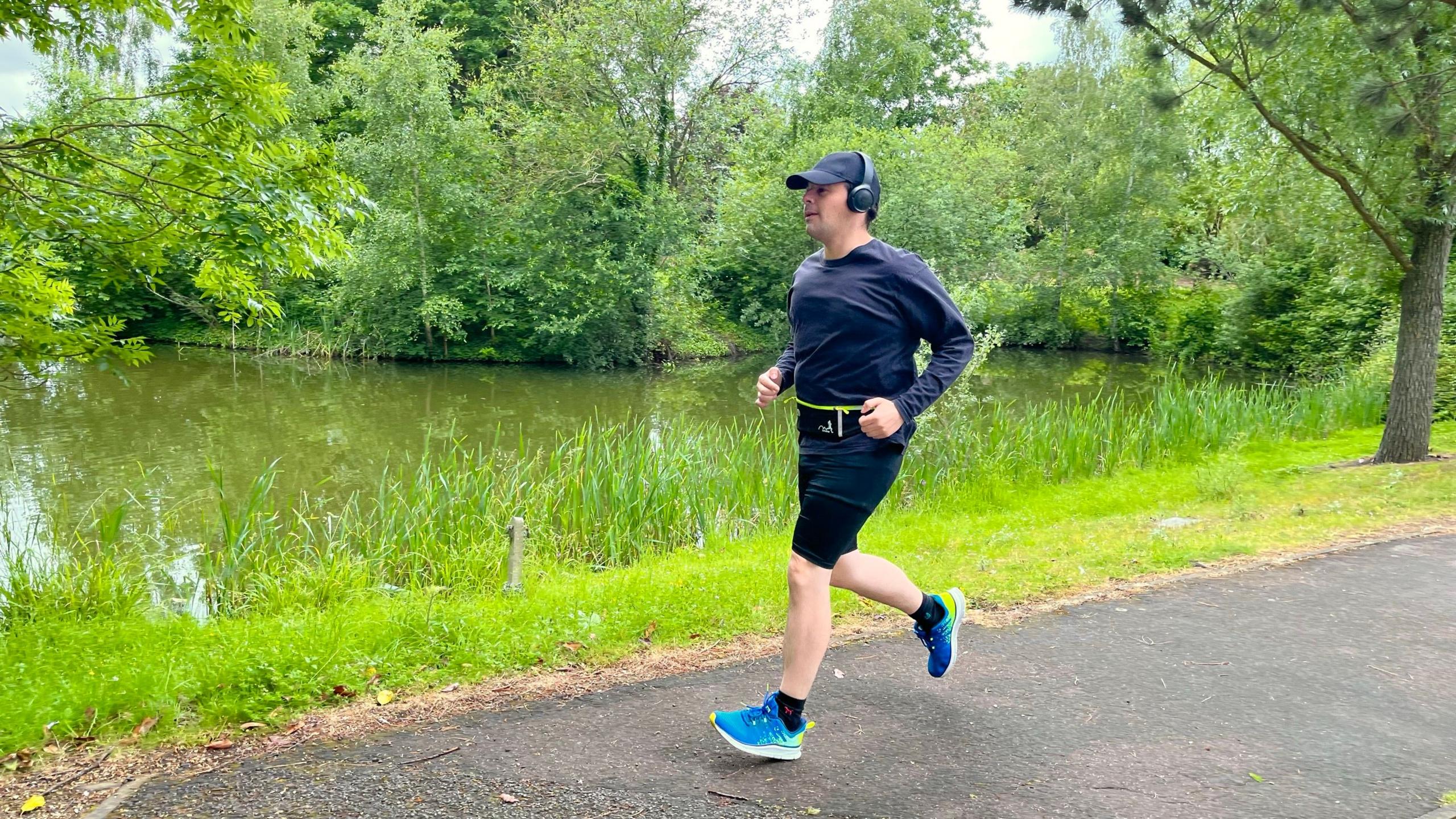 Jason Wilson in running clothes wearing a blue cap and headphones