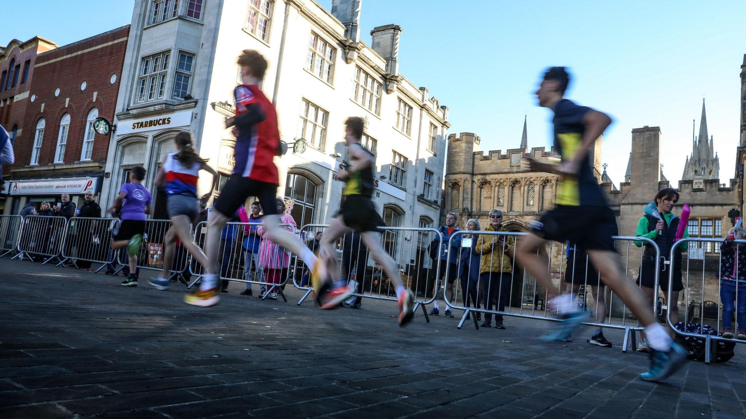 A candid image of runner taken from the side with the Cathedral in the background.
