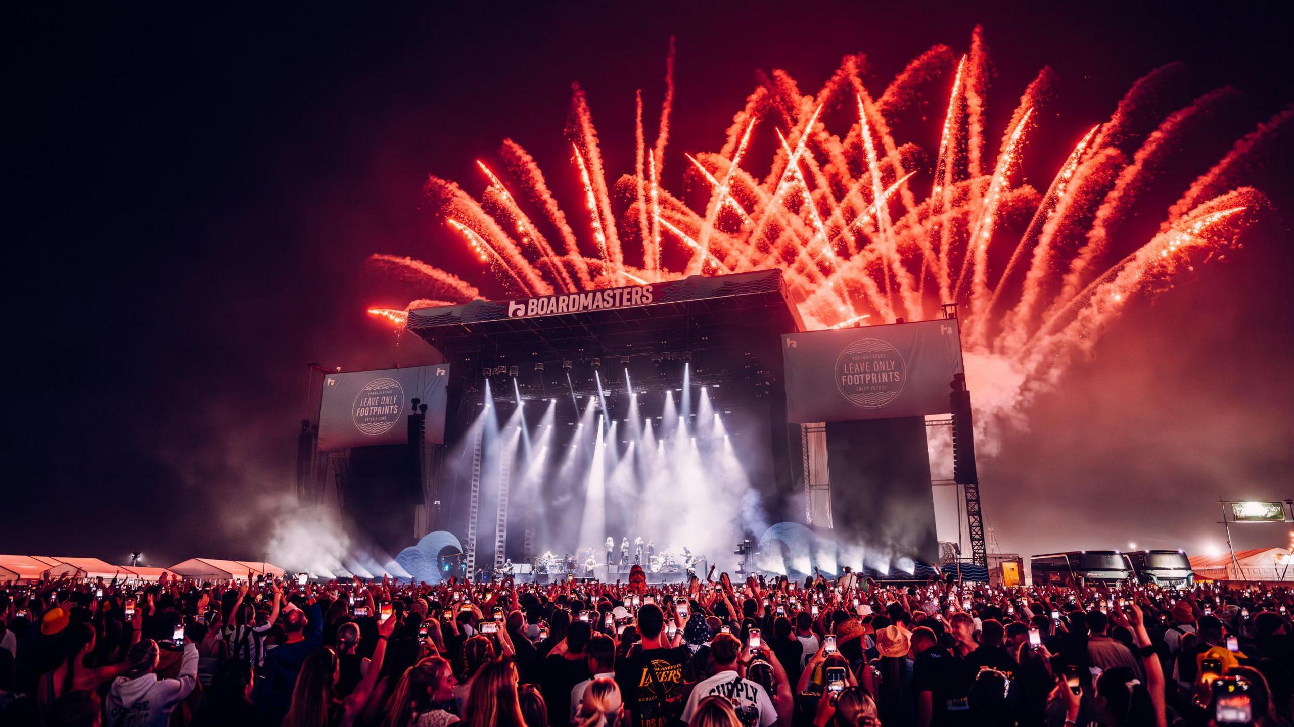 Main stage at a festival with fireworks going off into the night sky