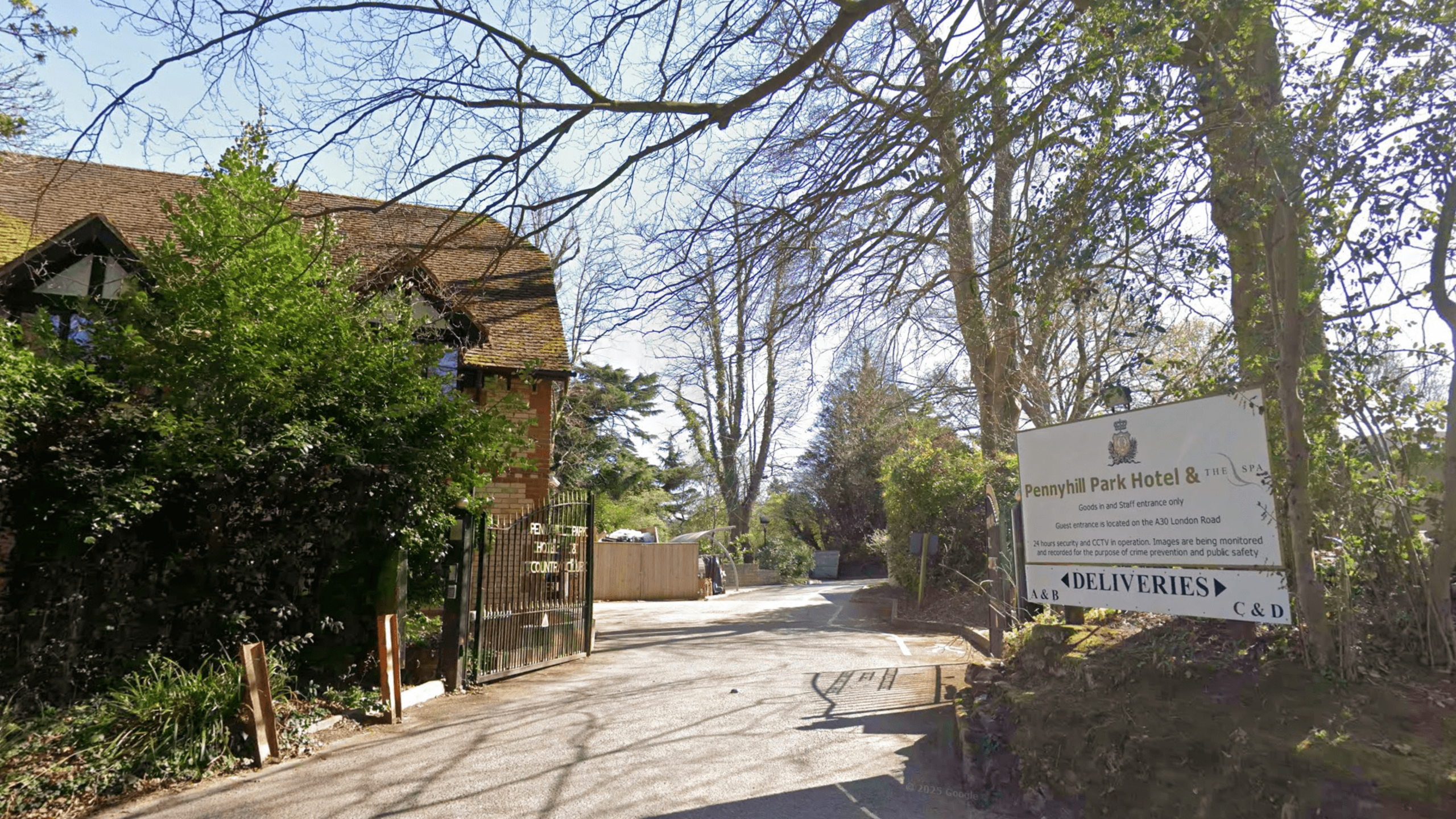 Exterior shot of the front gates and building of Pennyhill Park Hotel in Bagshot