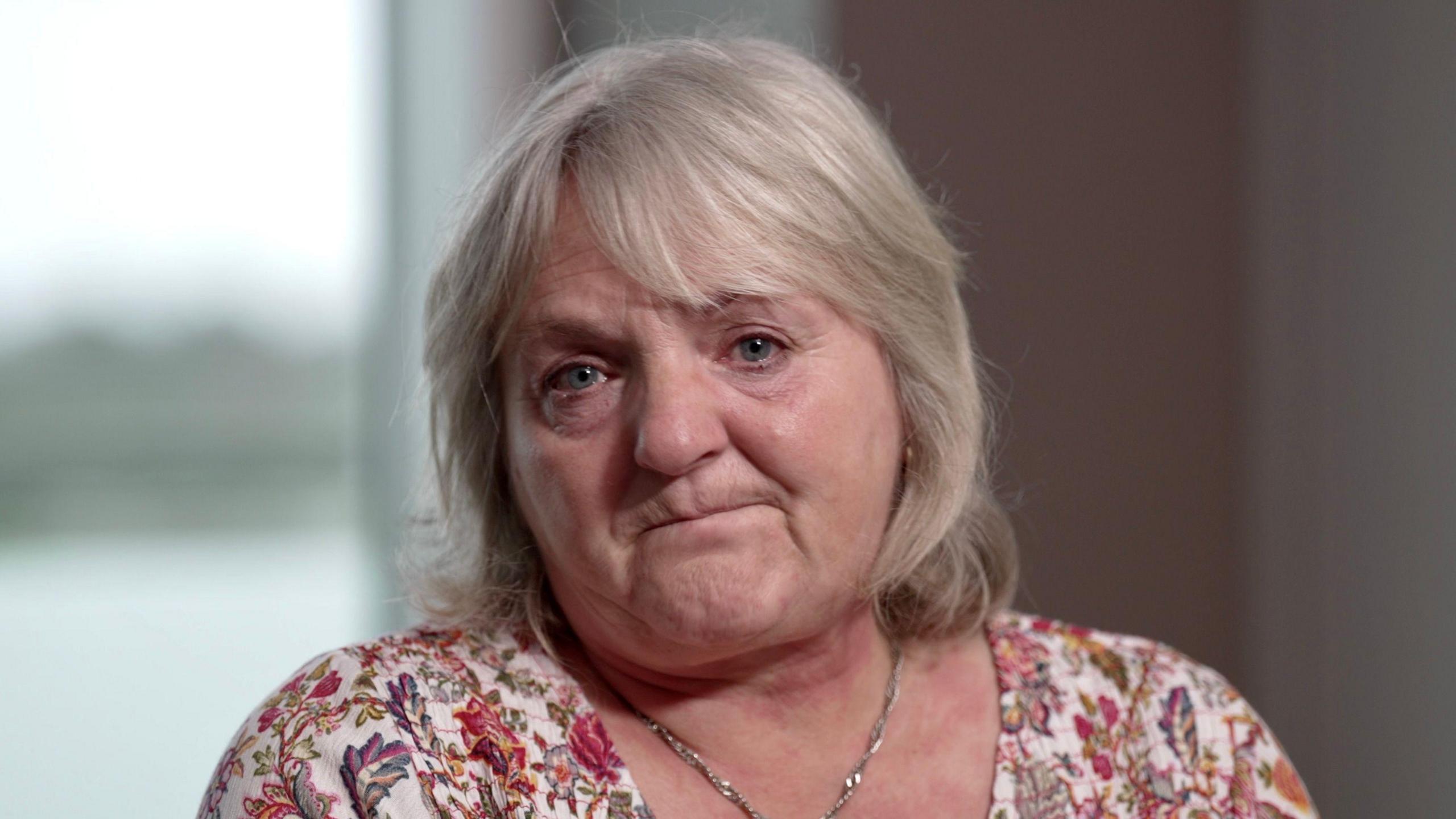 Woman looks at the camera with tears in her eyes