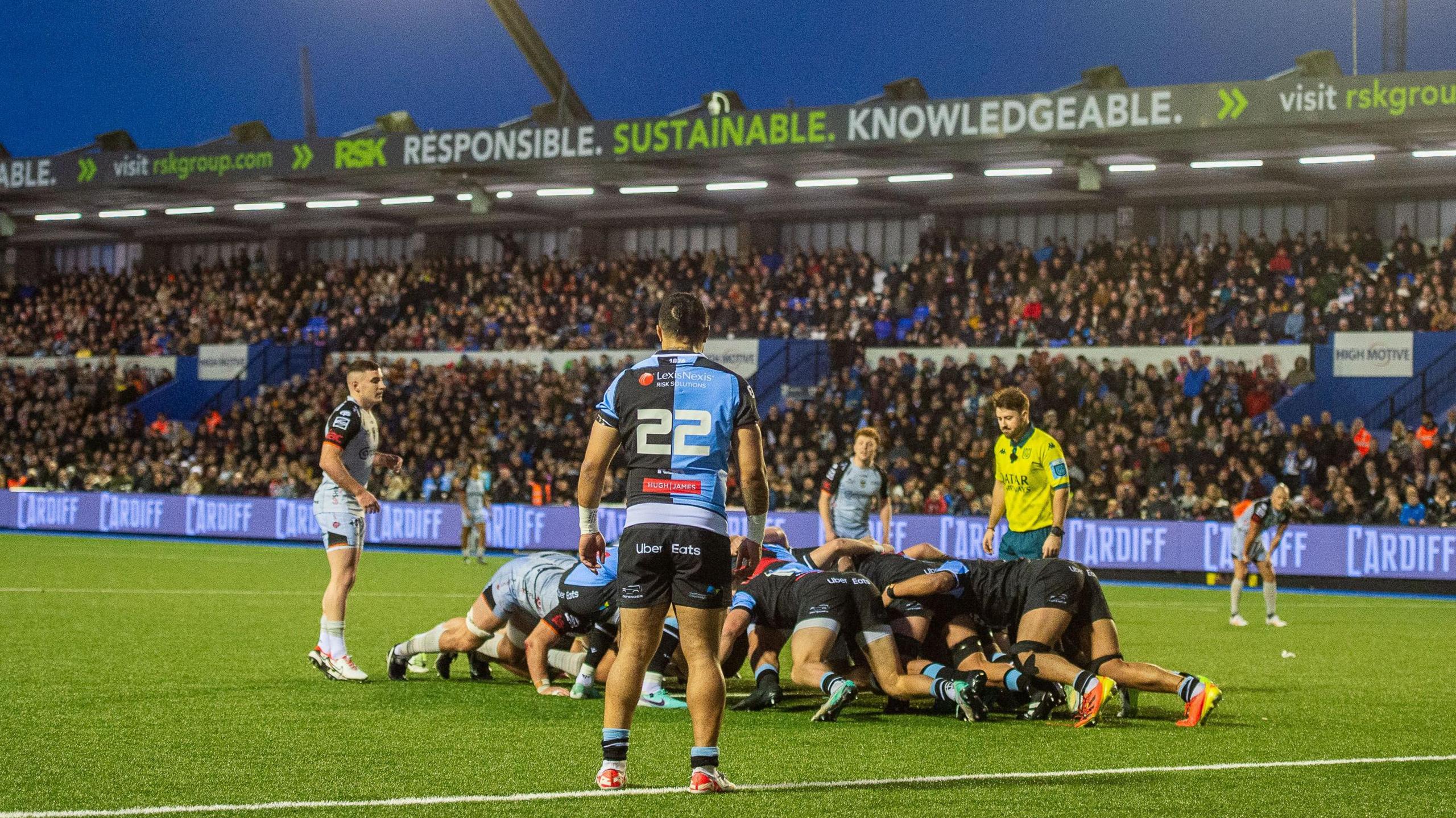 A scrum between Cardiff and Dragons in front of large crowd