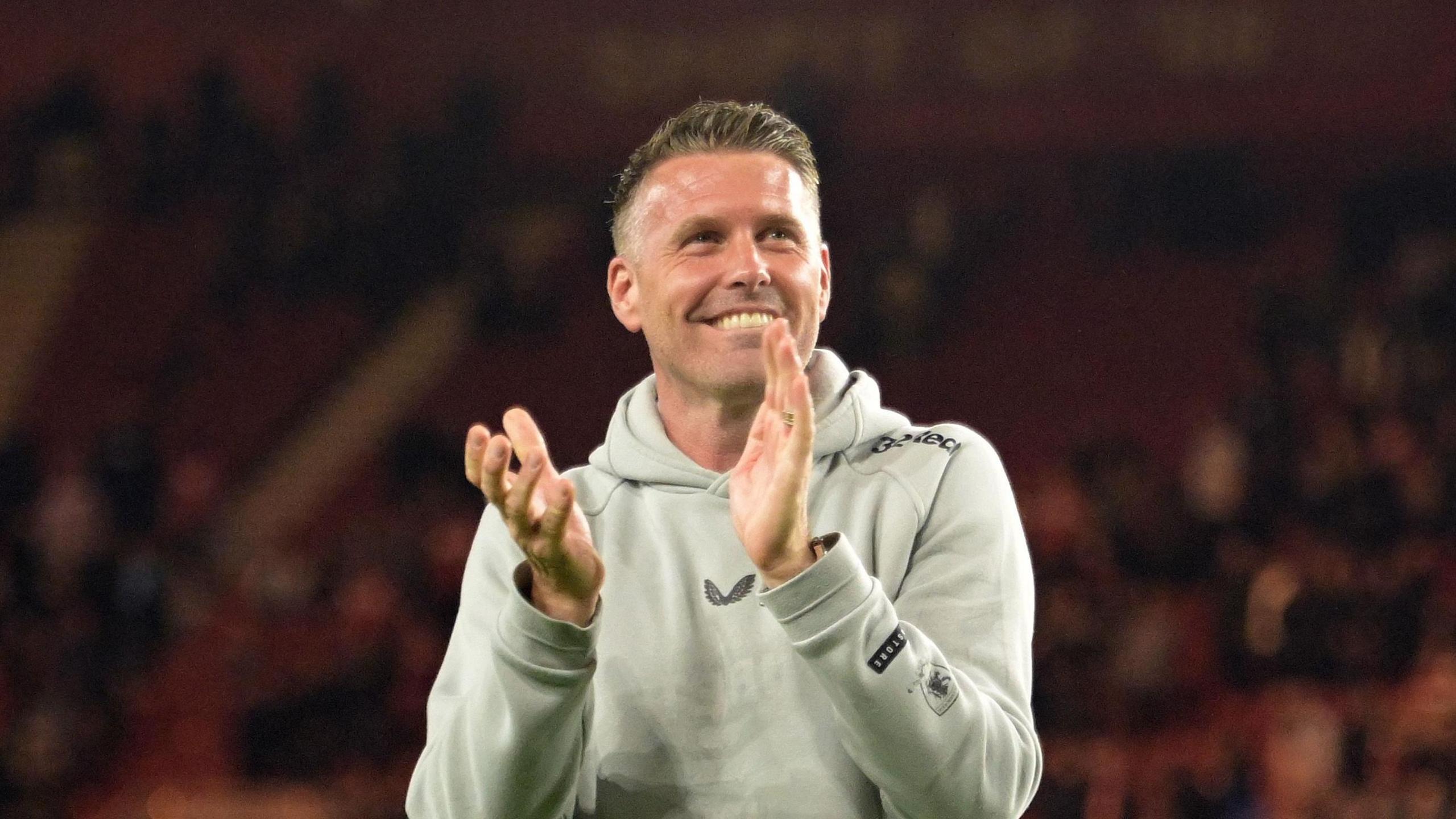 Rob Edwards, with a beaming smile, claps the Middlesbrough fans after their win over West Brom