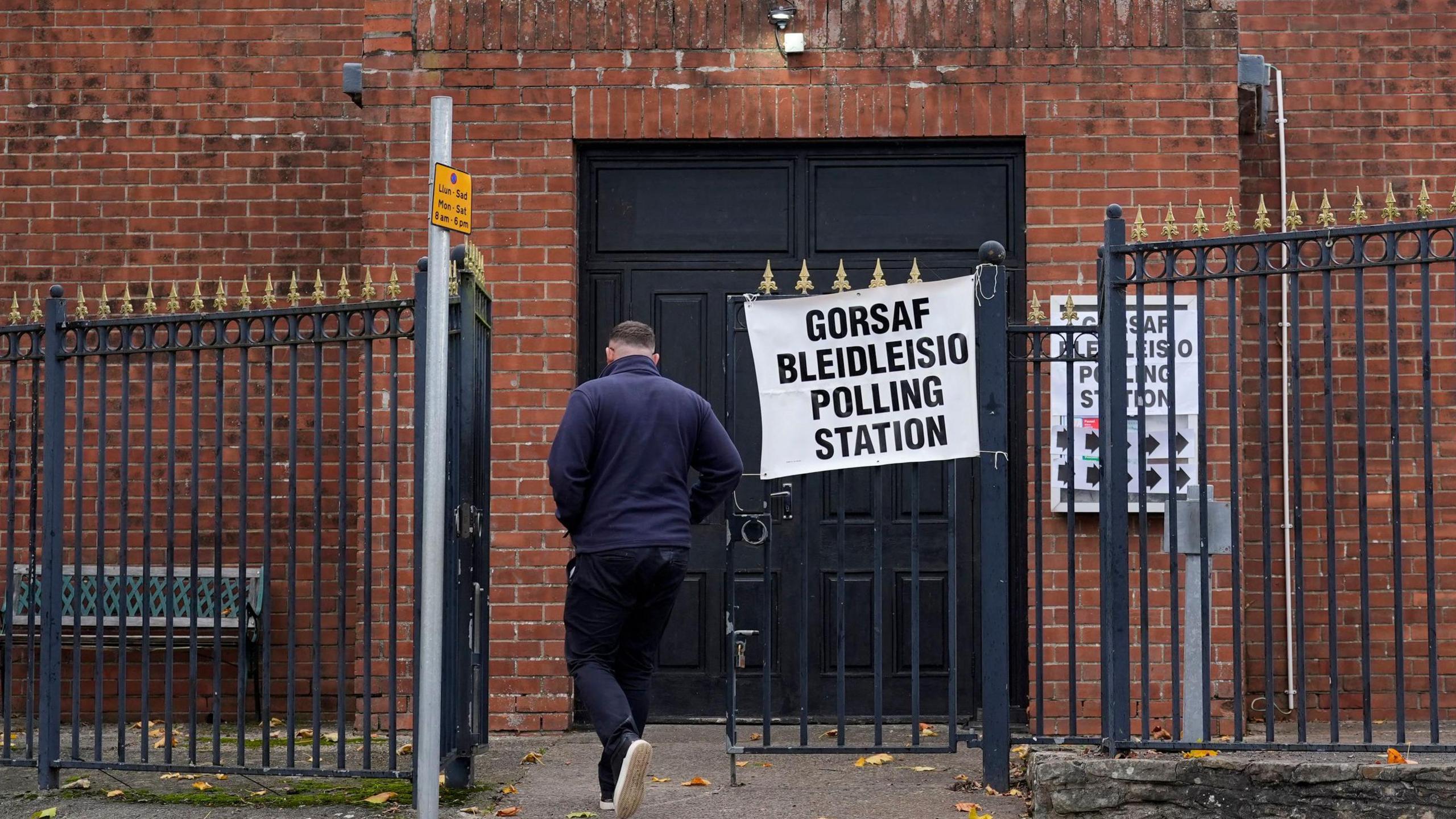 A person in a blue top is seen entering a polling station