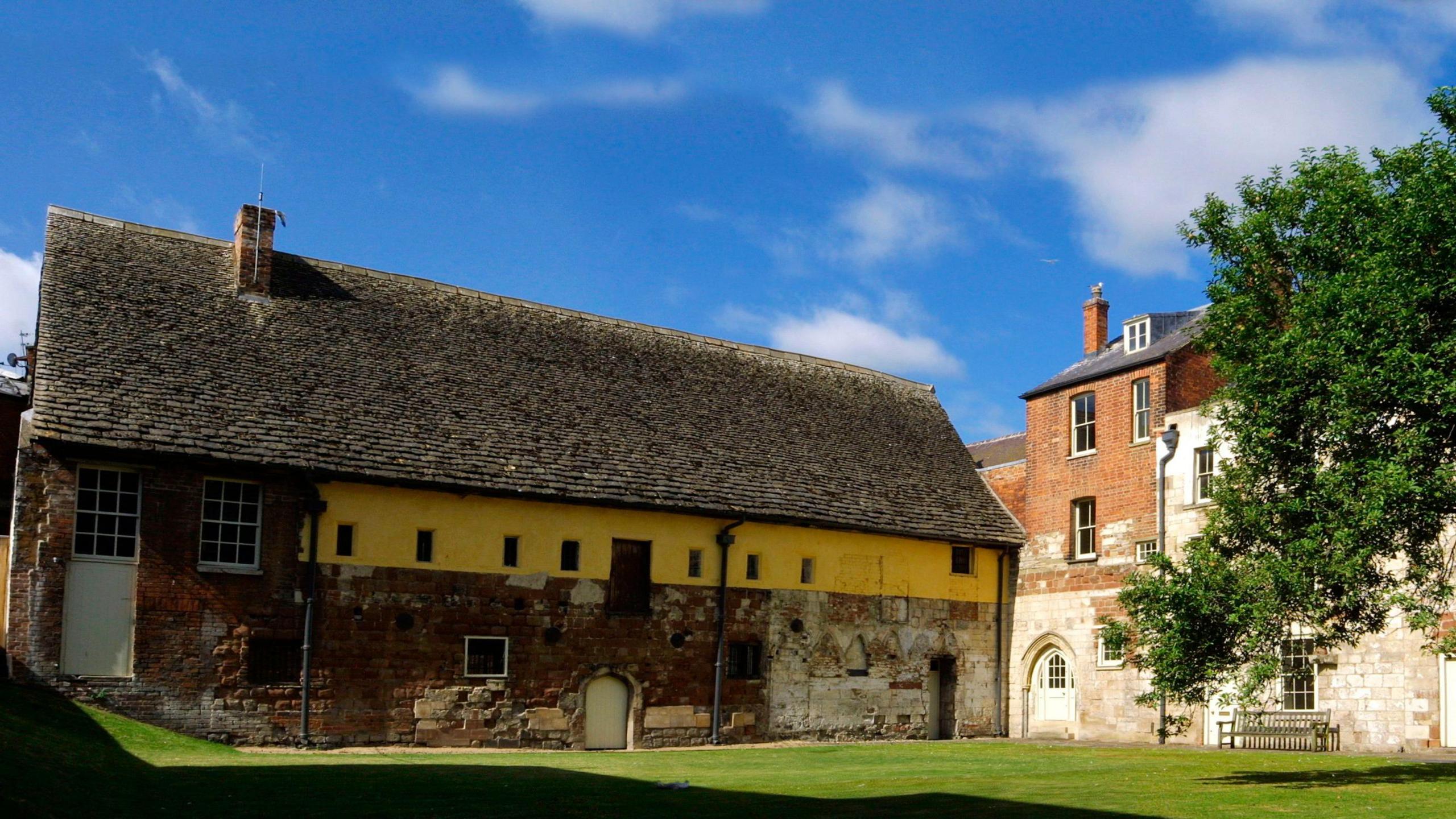 Blackfriars Priory, with yellow and brown brickwork,  on a sunny day.