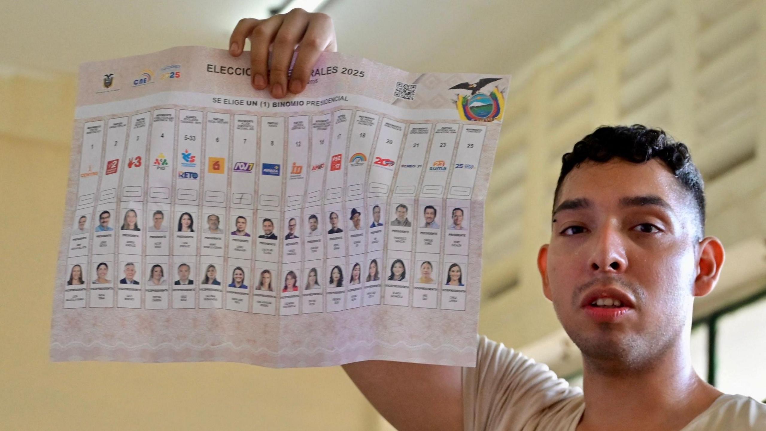 An Ecuadorian man holds up a ballot paper during the presidential election