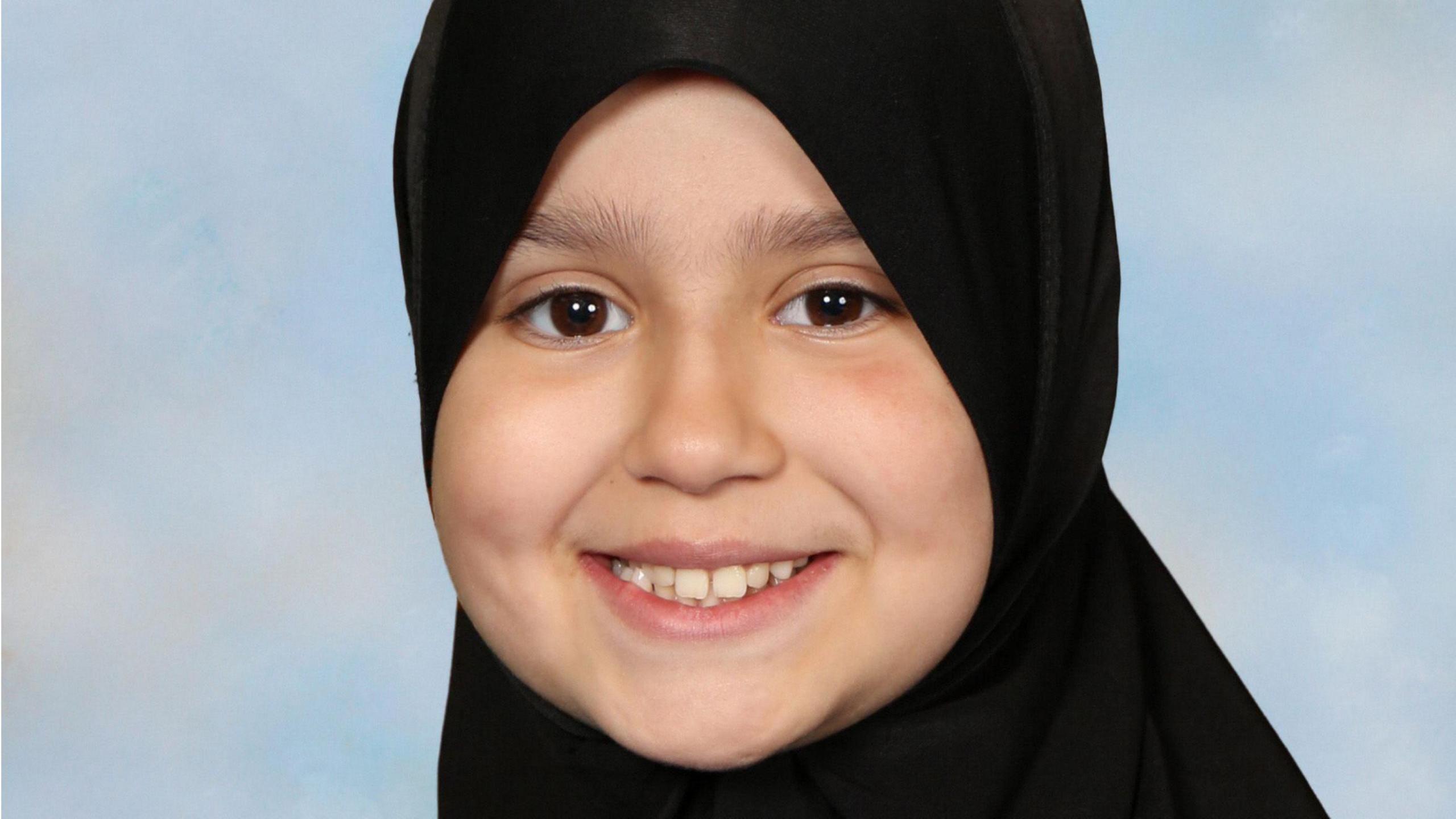 Sara Sharif wearing a black hijab. She is smiling and looking directly at the camera. 