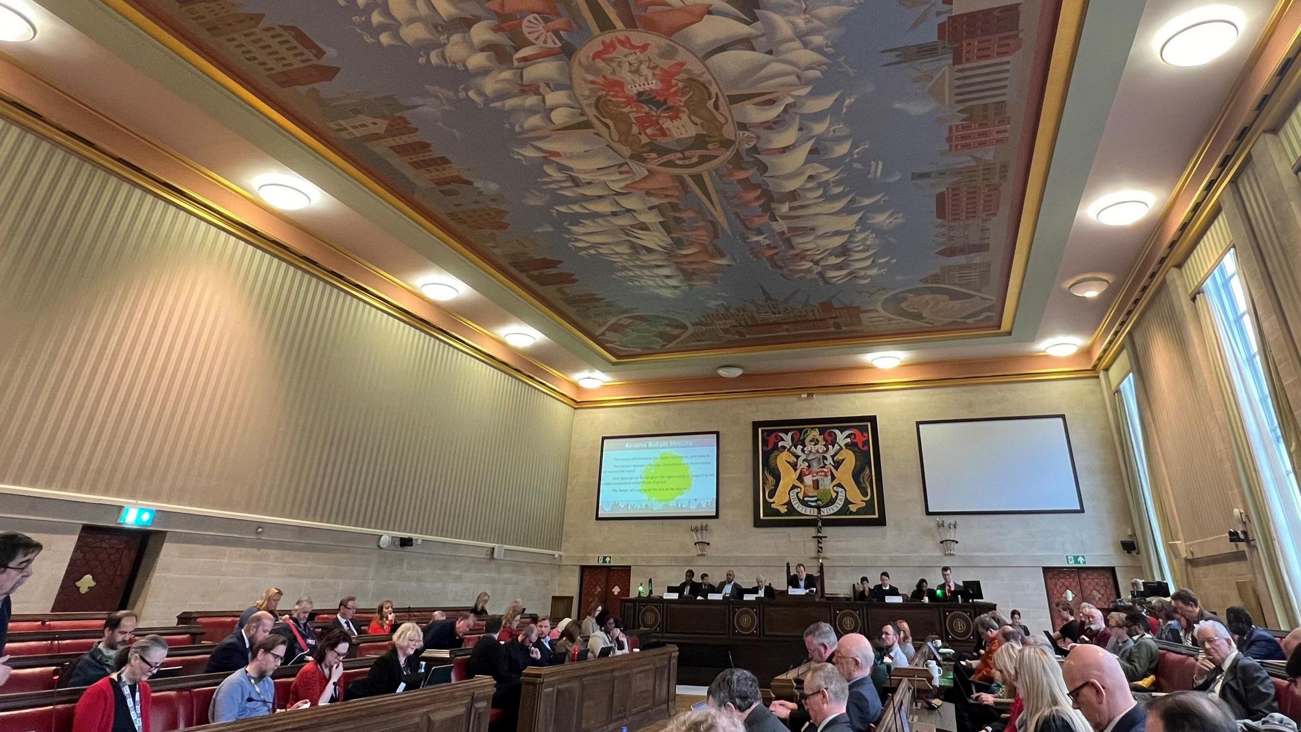 Inside the Council chamber at City Hall in Bristol, with people sat on the benches