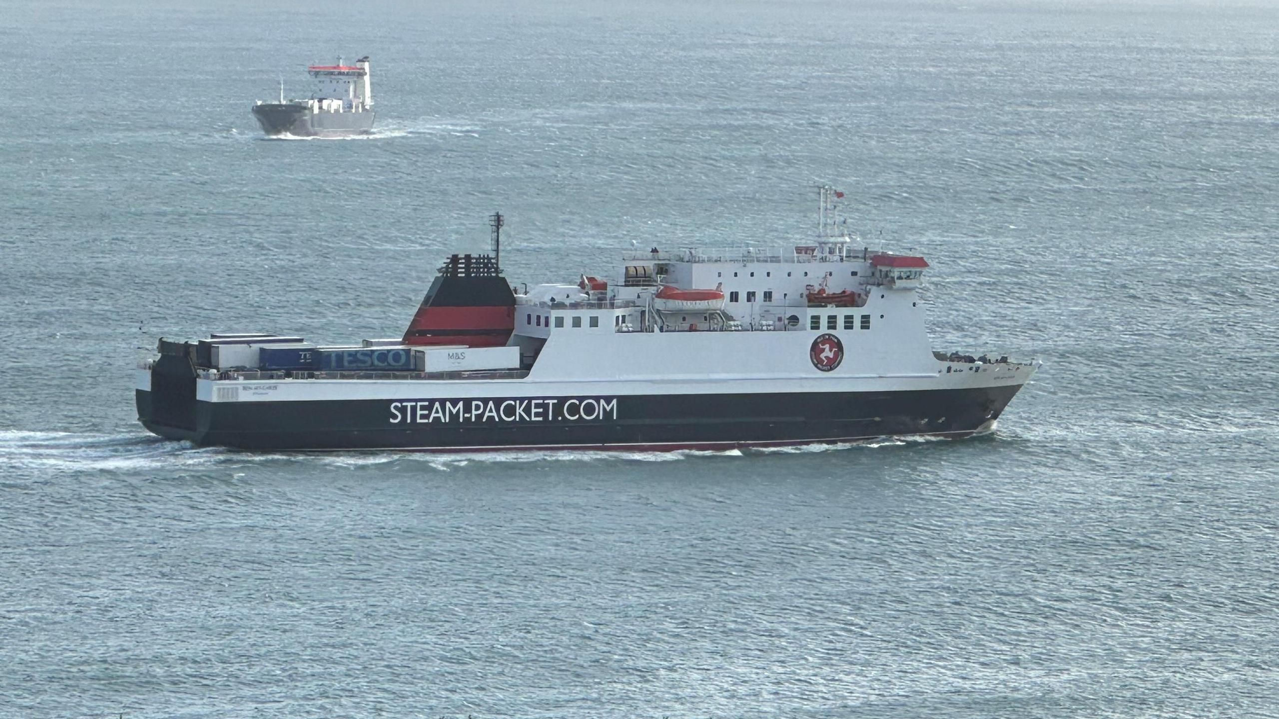 The Ben-My-Chree, which is painted in the Isle of Man Steam Packet Company's black, white and red livery, sailing across Douglas Bay, with freight MV Arrow in the background heading in the opposite direction.