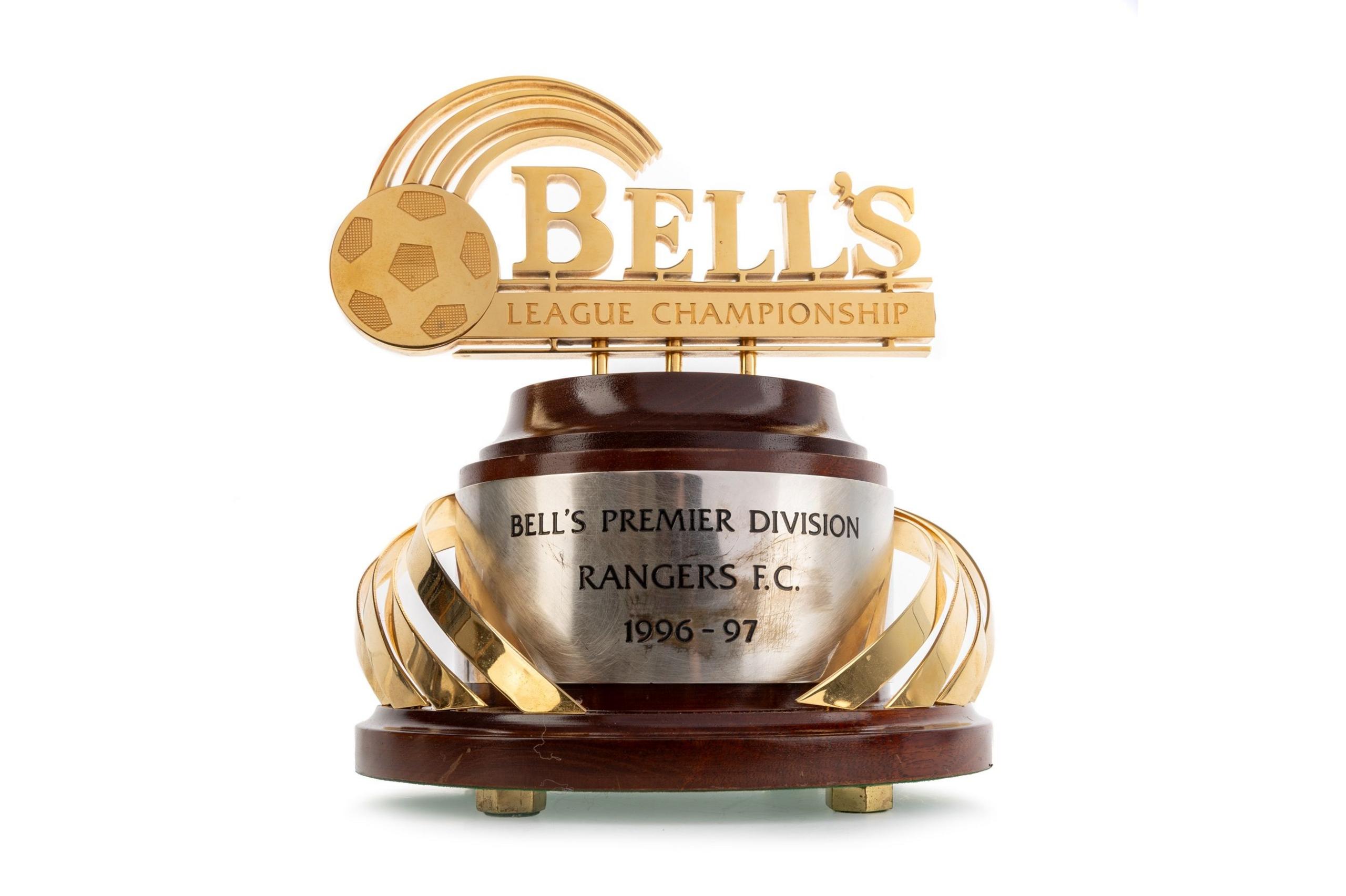 A wooden trophy base with a gold topper of the word BELL'S with League Championship engraved underneath and a gold football. On the base there is a silver plaque engraved with BELL'S PREMIER DIVISION RANGERS F.C. 1996-97.
