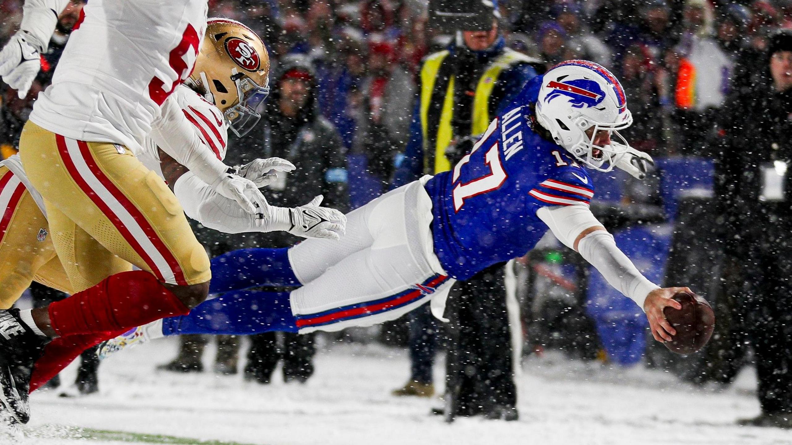 Buffalo Bills quarterback Josh Allen dives into the end zone to score a touchdown during the NFL game against the San Francisco 49ers in the snow