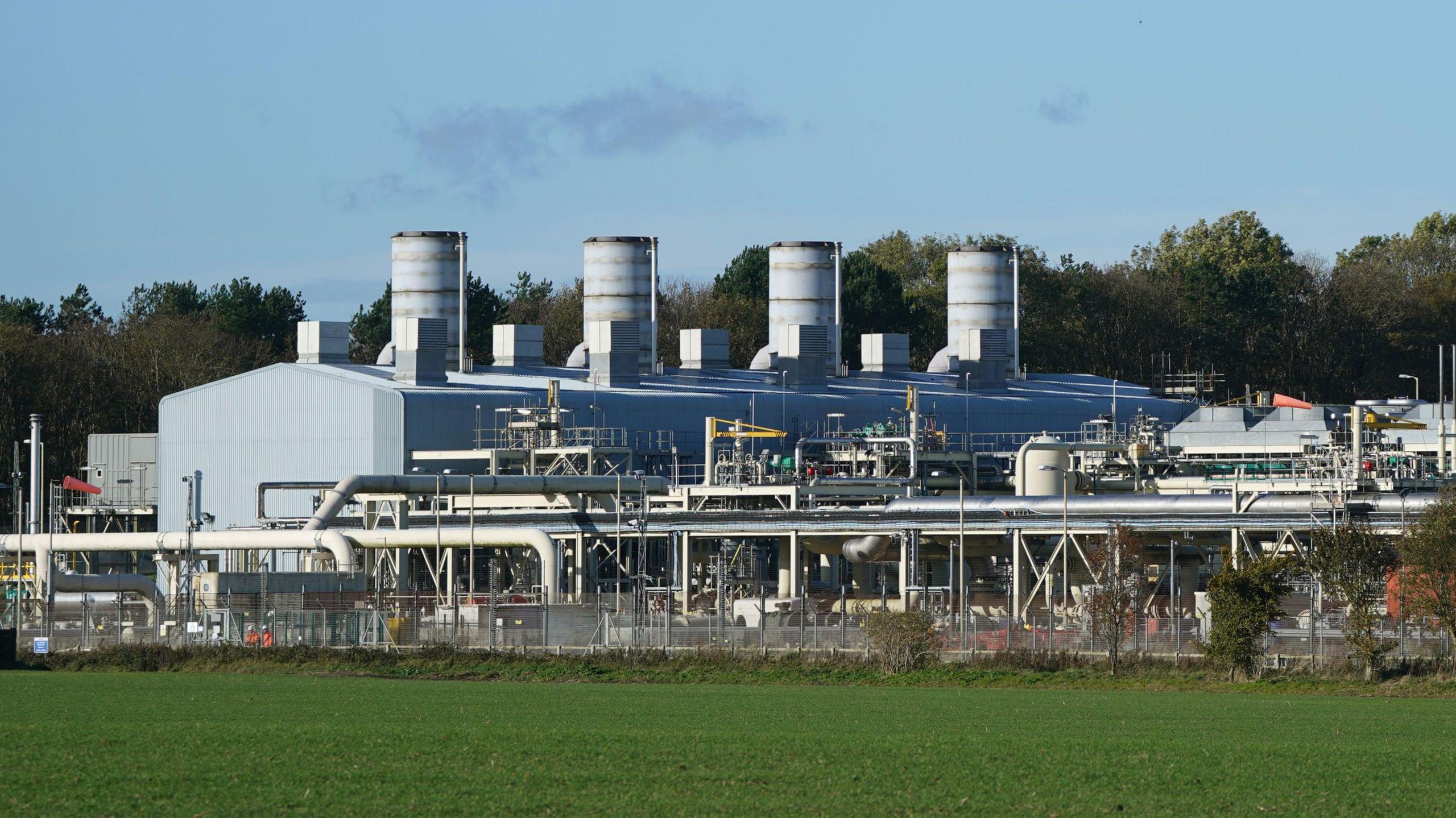 Part of the Bacton gas terminal site, with four large stacks on top of a large warehouse-type building.