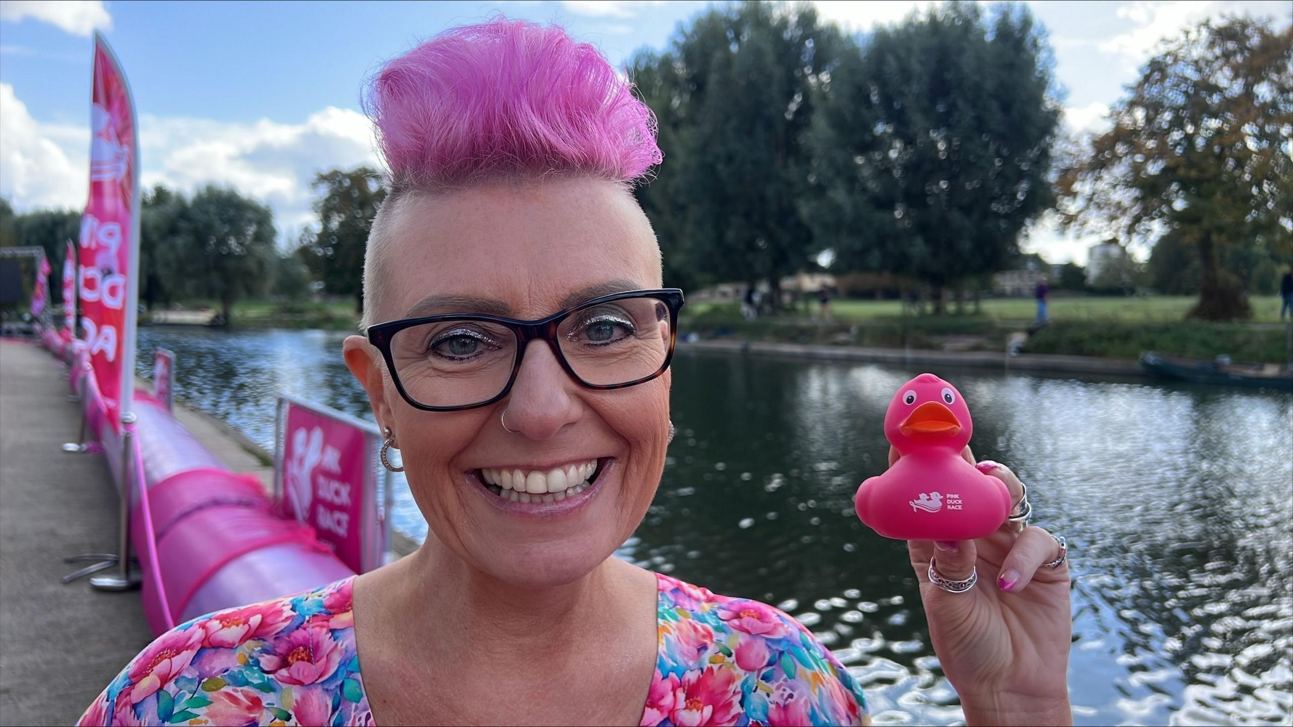 Lisa, with pink hair, holding a rubber duck