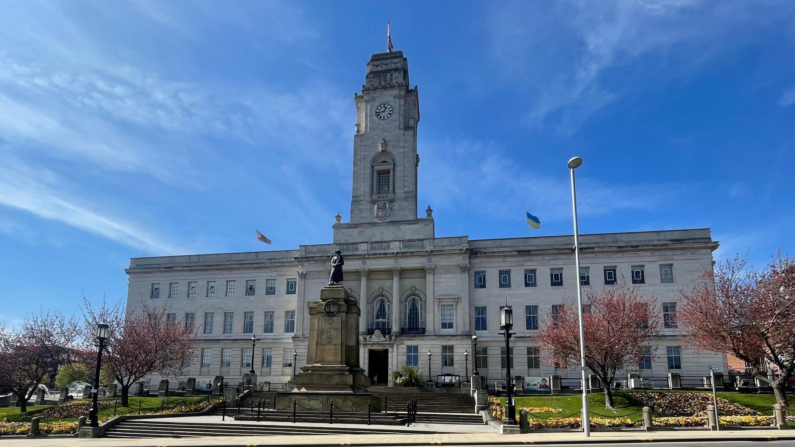A large white brick town hall building on a sunny day