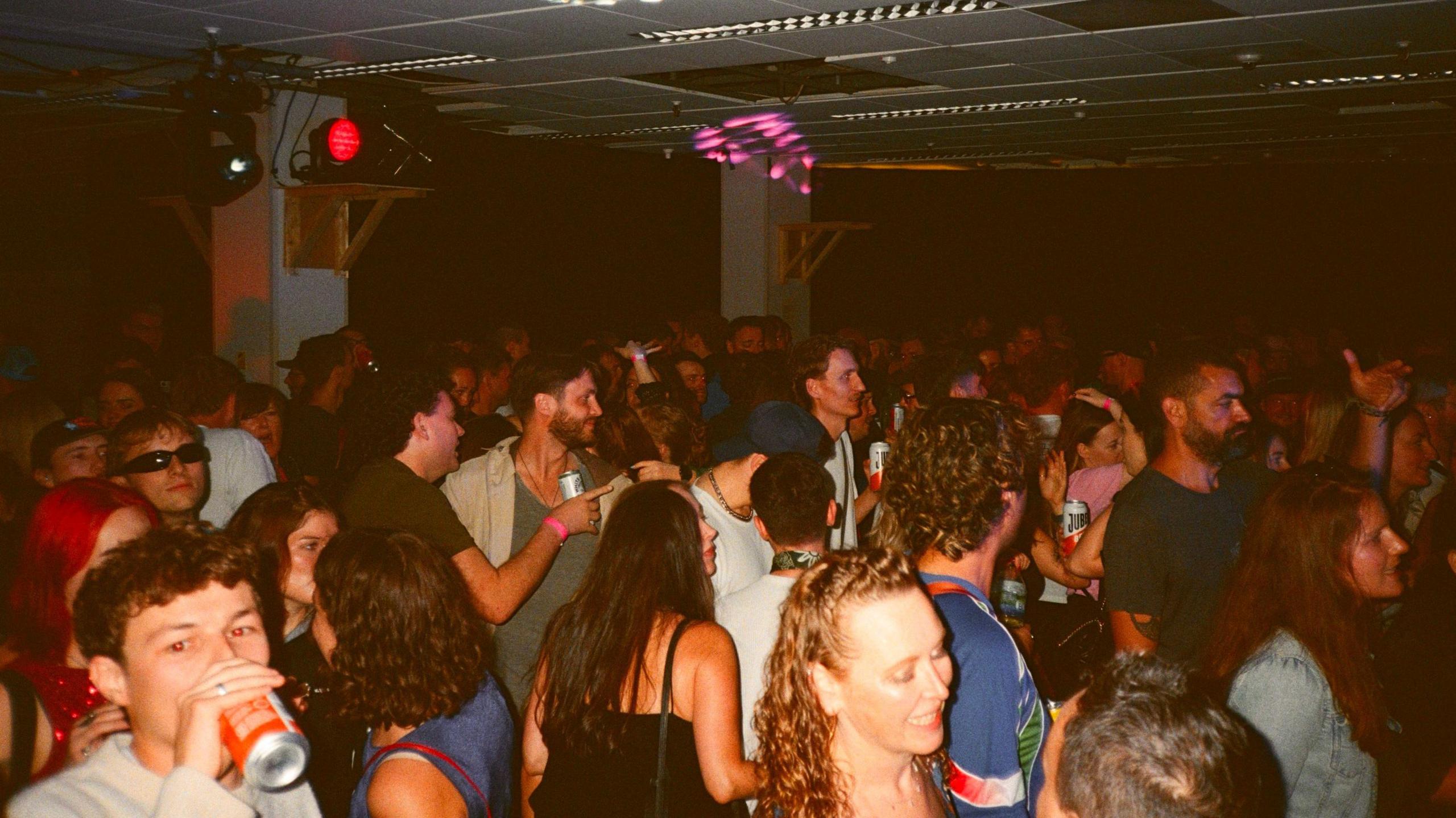 A crowded dance floor, people are smiling and talking to each other
