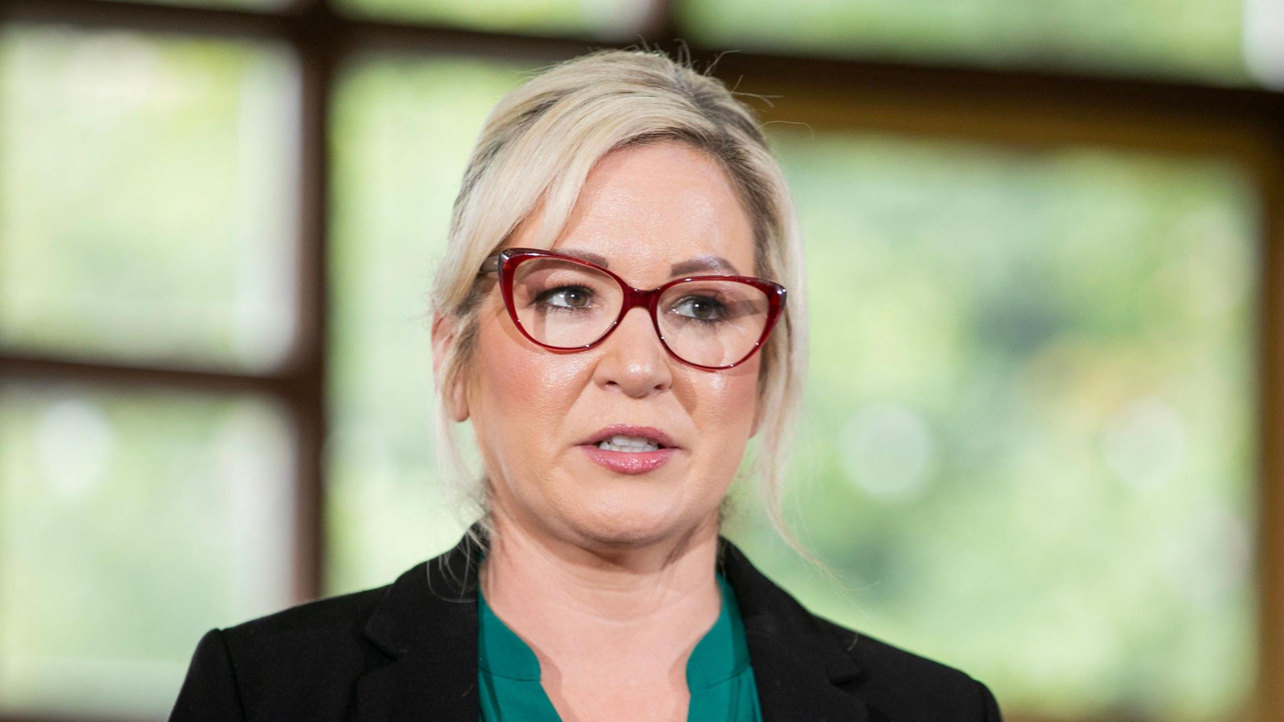 Michelle O’Neill wearing a black blazer and green shirt 