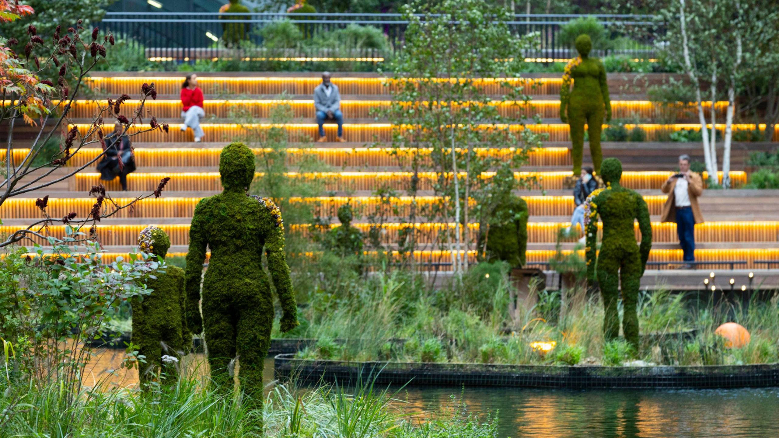 Large moss-covered statues on floating islands in the dock waters