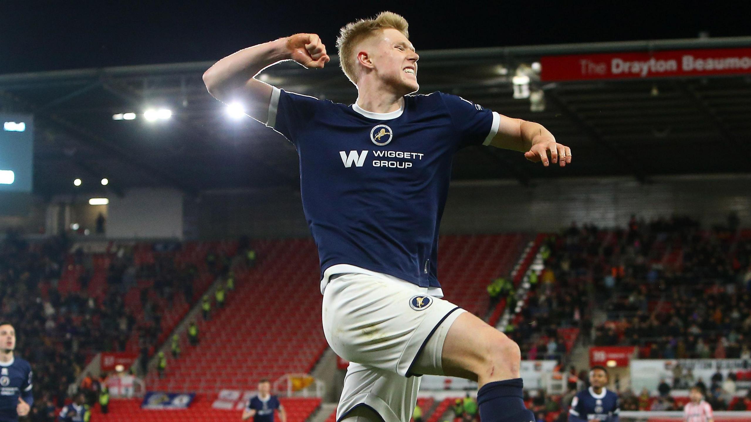 Josh Coburn leaps in the air and celebrates with a fist pump