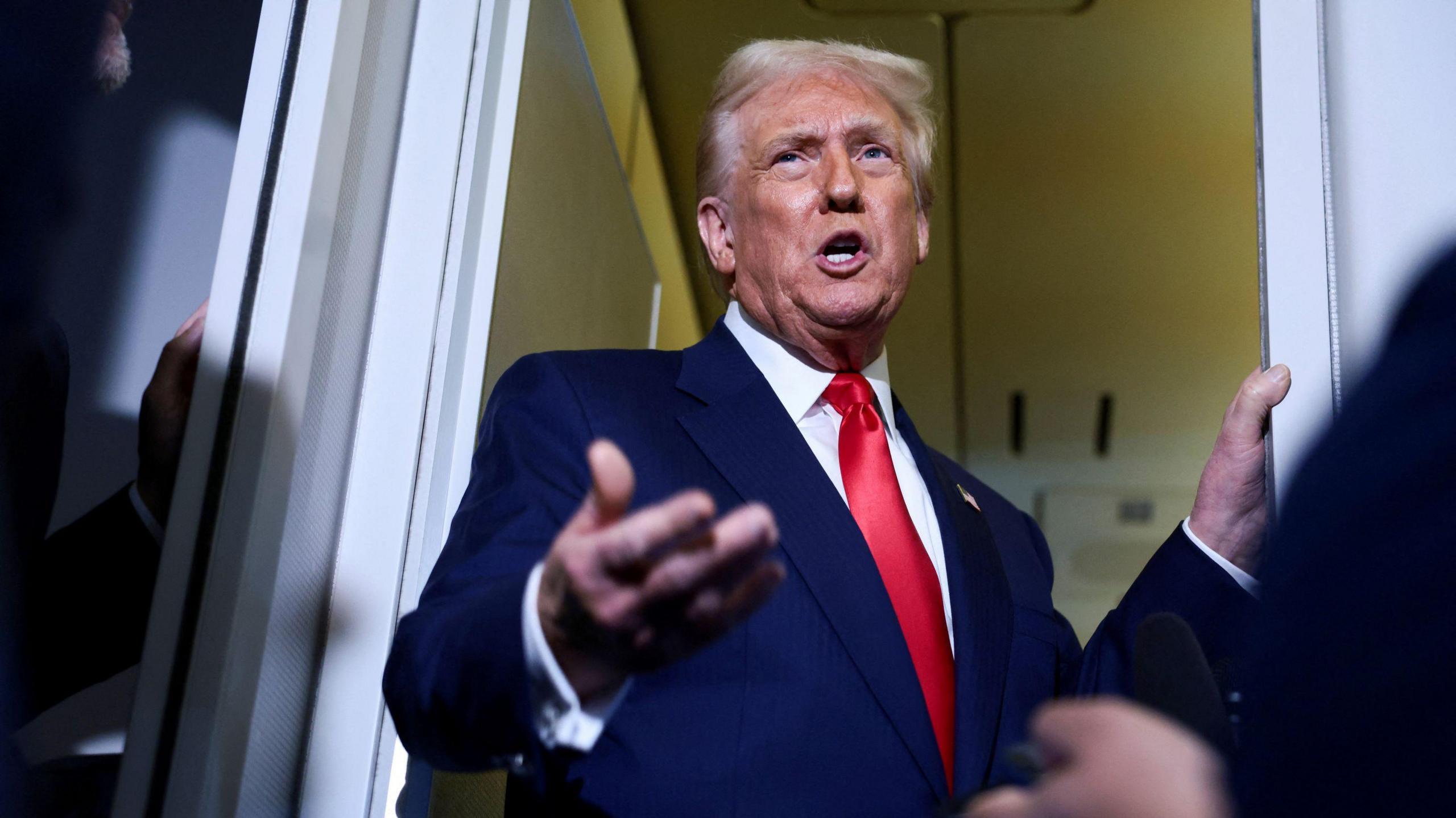 U.S. President Donald Trump speaks to members of the media on board Air Force One en route to the U.S., October 30, 2025