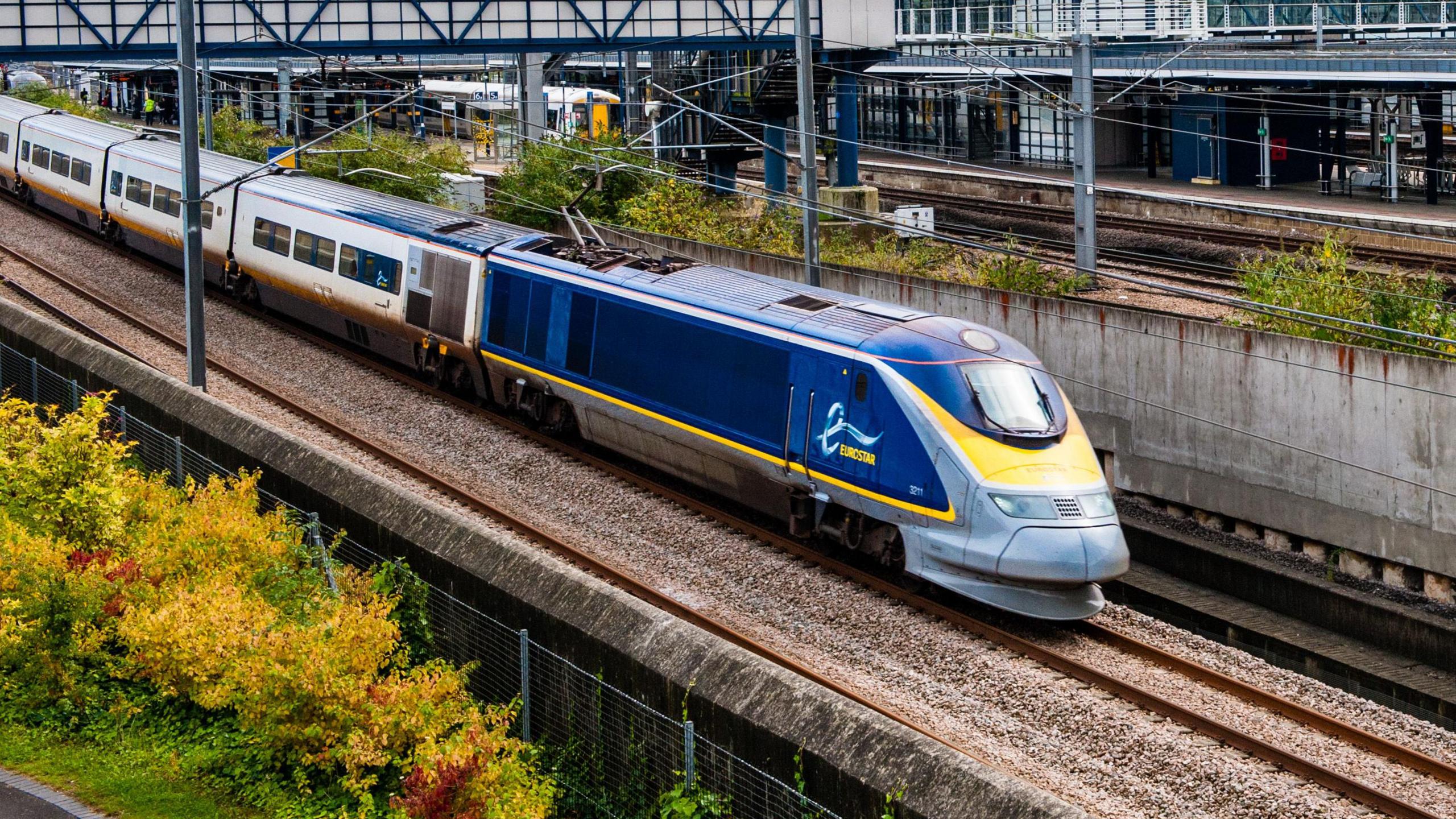 A blue and white Eurostar training on train tracks.