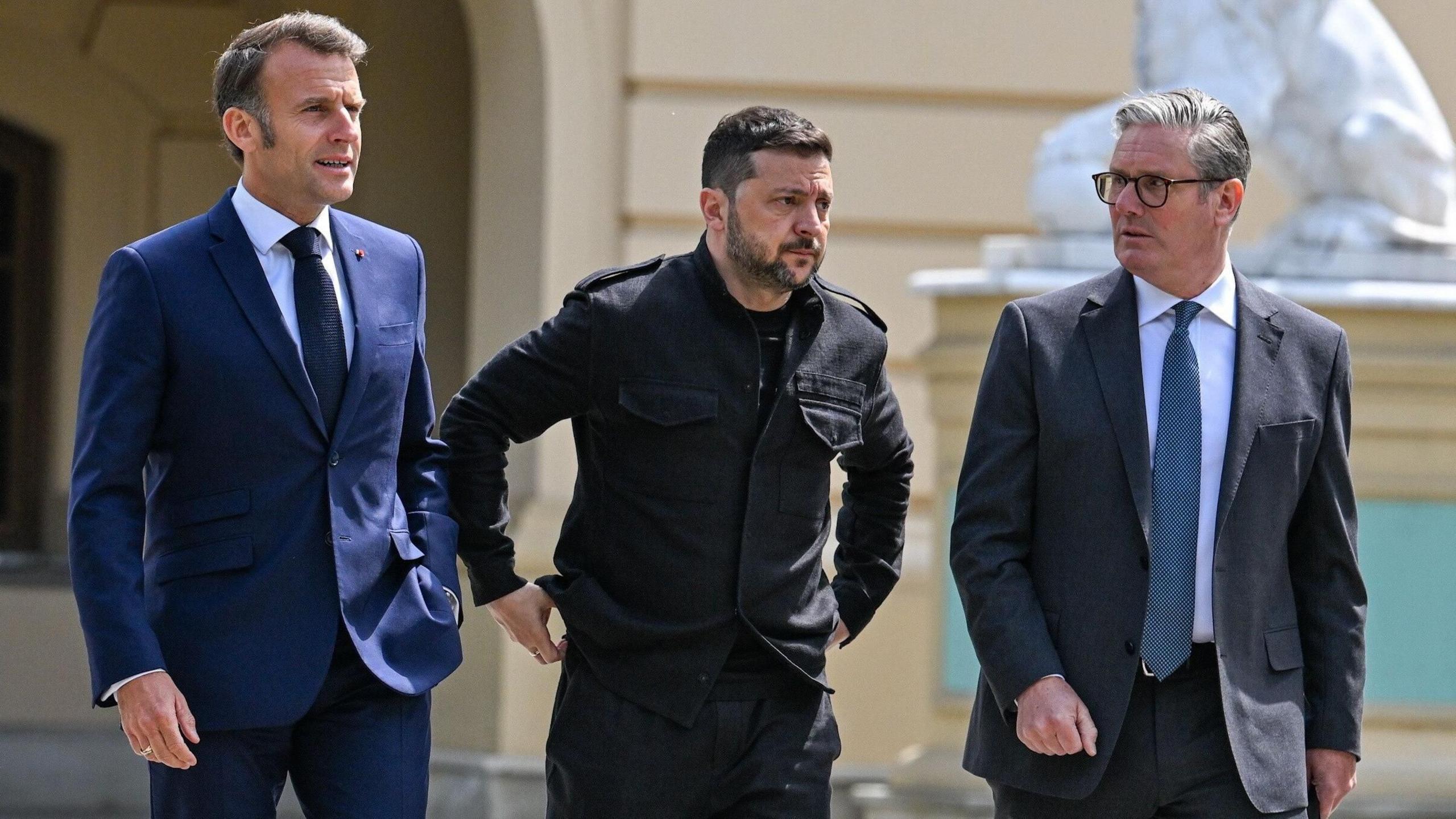 France's President Emmanuel Macron, Ukraine's President Volodymyr Zelensky, and Britain's Prime Minister Keir Starmer walk together with Zelensky moving his hands