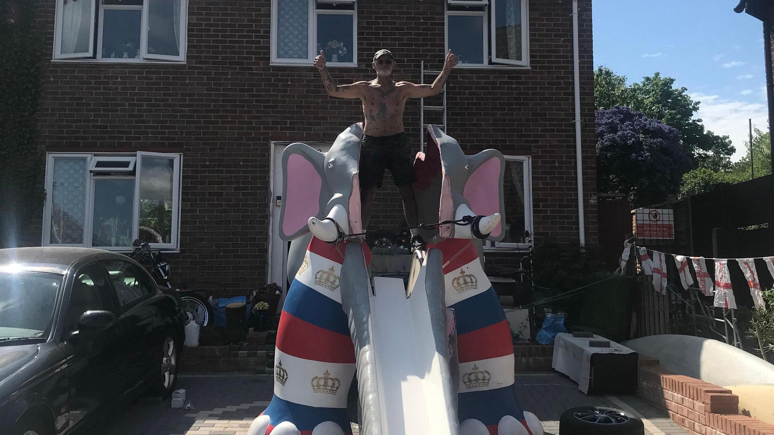 A man stood on top of a 20ft elephant slide.