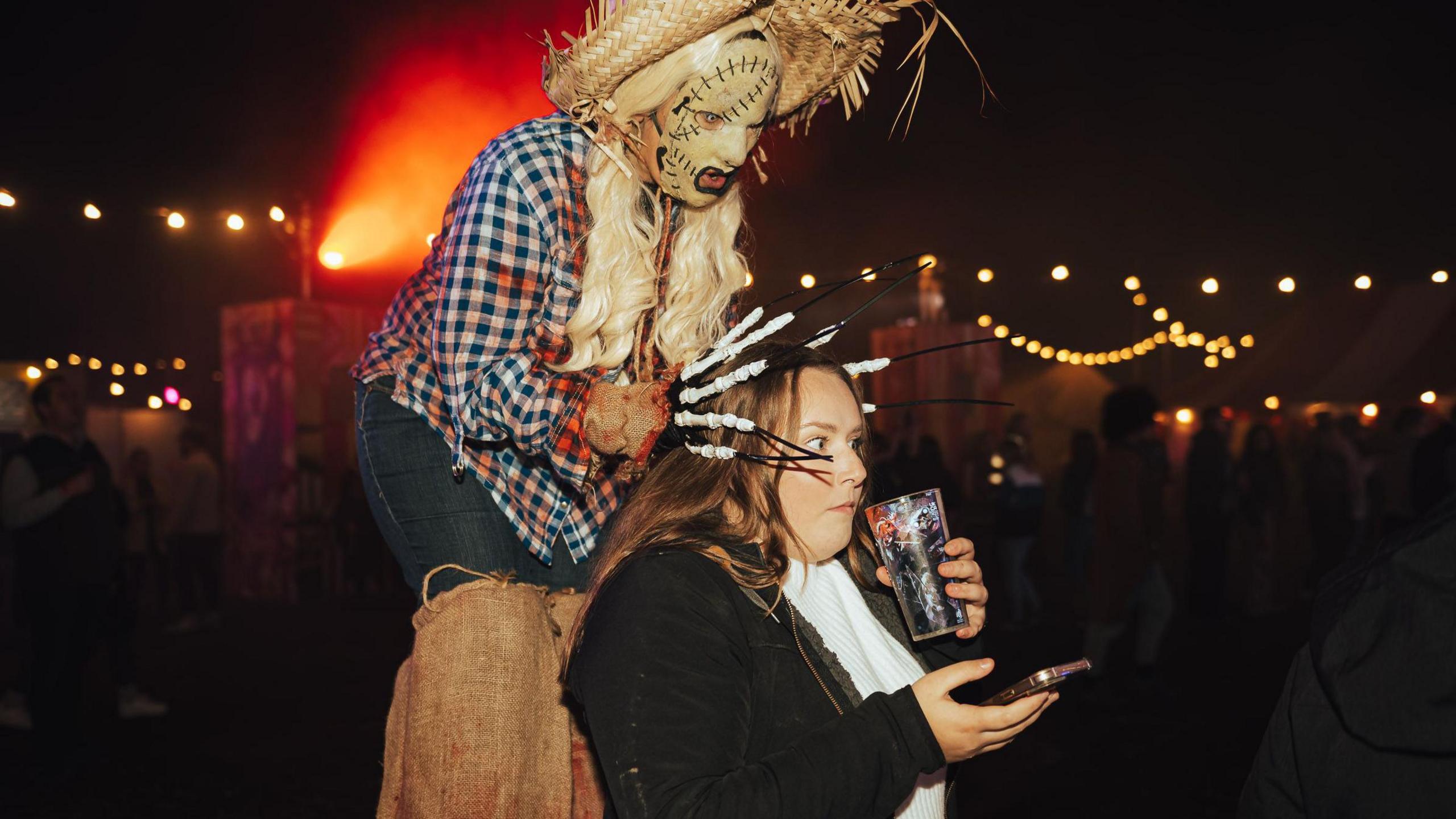 A woman freezes as she is gripped from behind by a scary scarecrow creature during the FEAR Halloween exhibition at Avon Valley adventure park