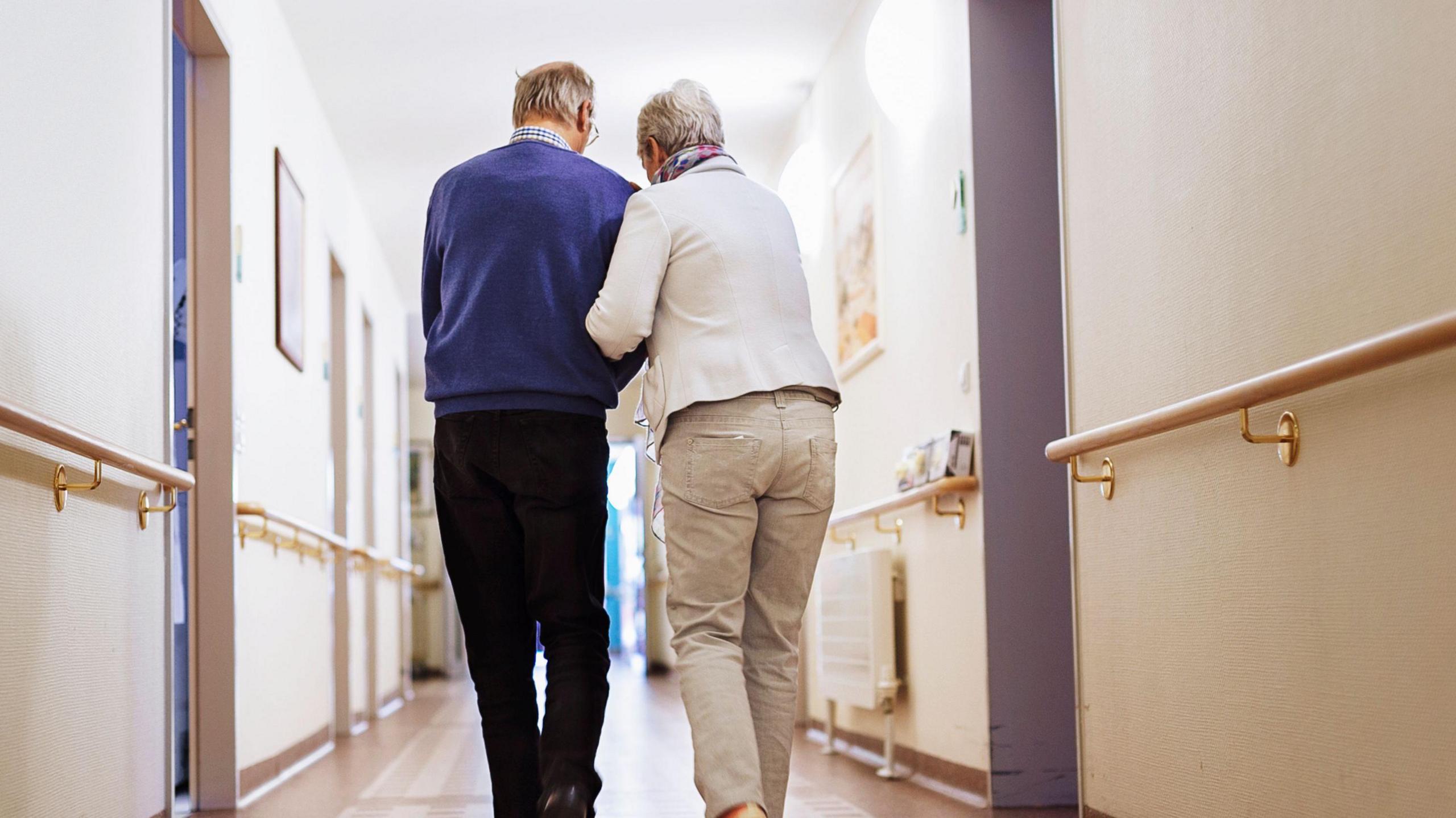 two people walking down a corridor 