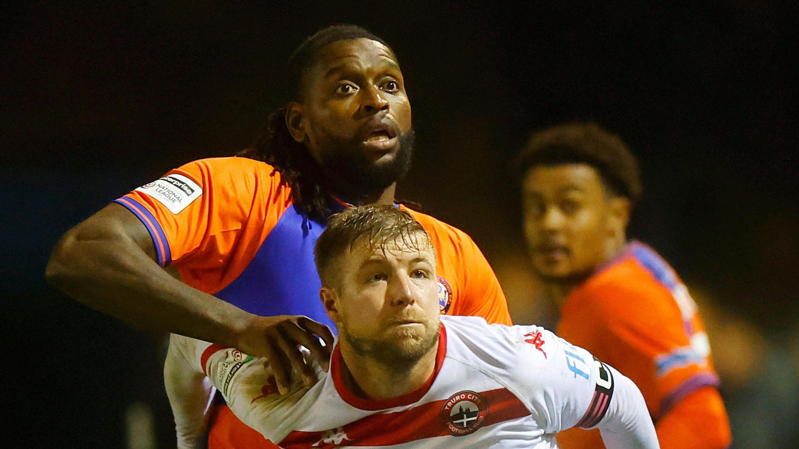 Jay Emmanuel-Thomas with his right hand on the shoulder of a Truro City player
