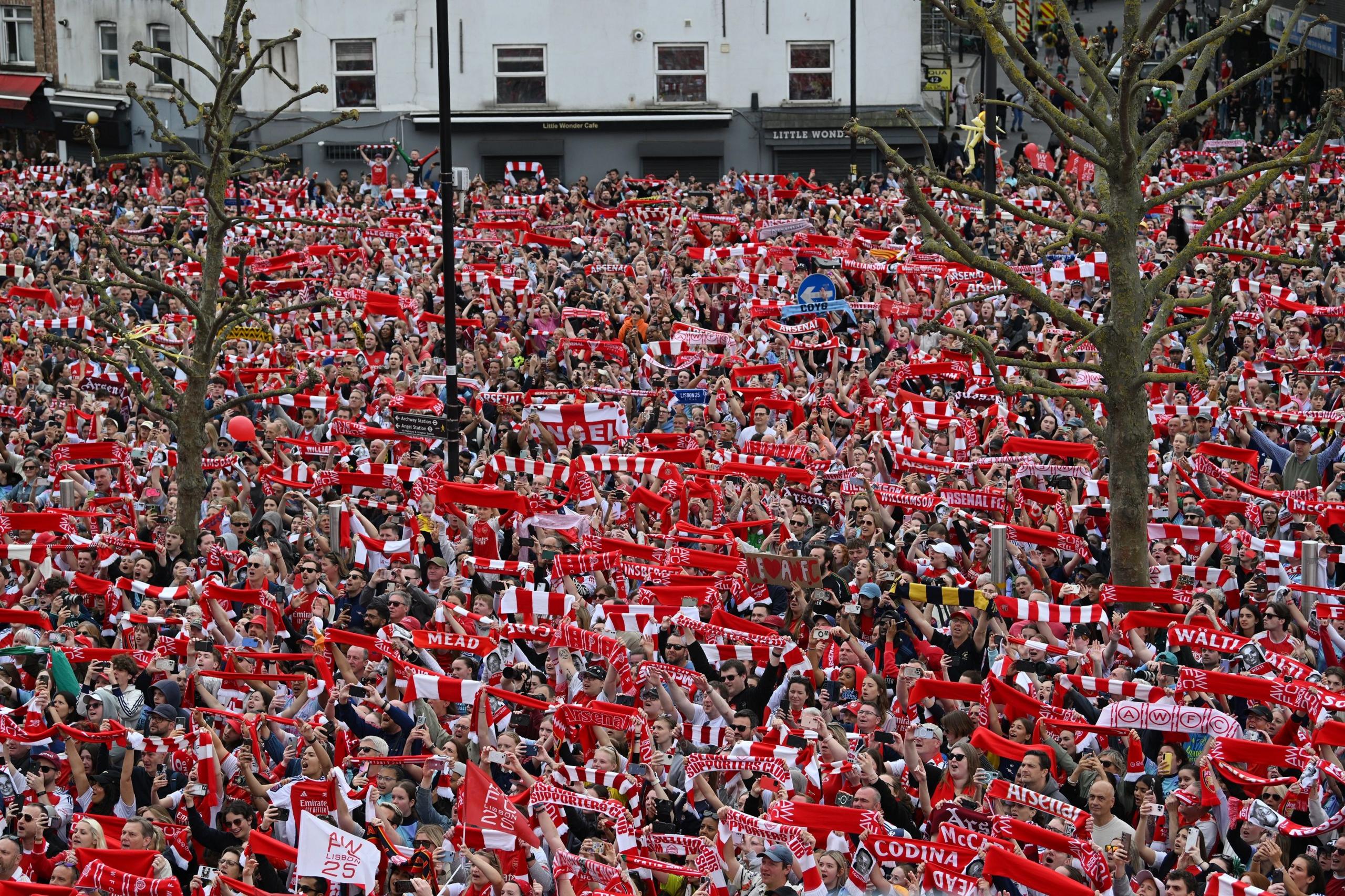 Arsenal fans all hold up club scarfs