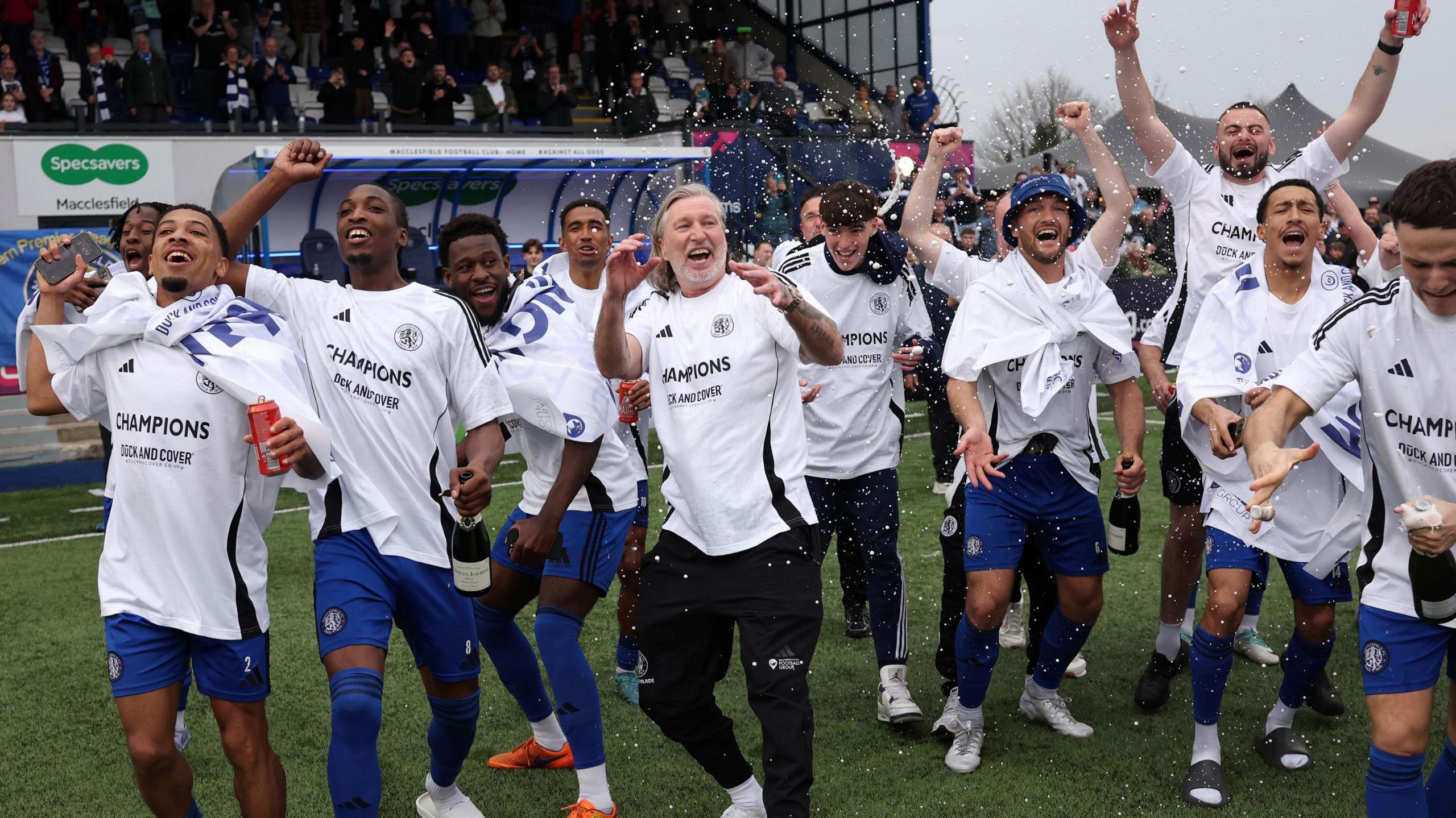 Robbie Savage (centre) celebrates on the pitch surrounded by Macclesfield players as they win promotion