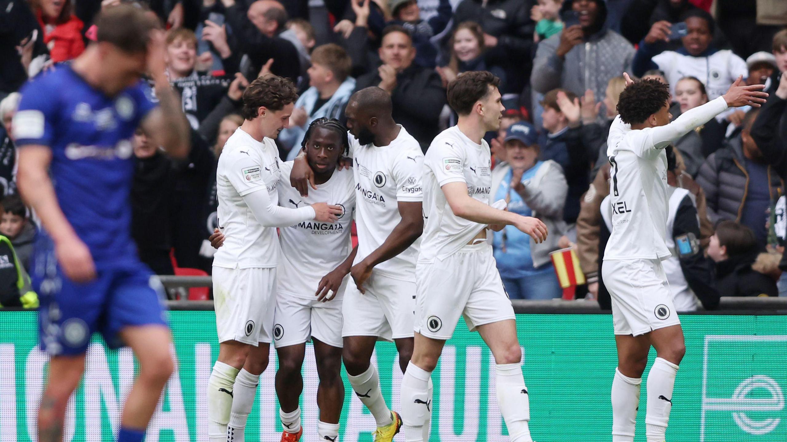 Abdul Abdulmalik of Boreham Wood celebrates scoring his team's second goal with teammates 