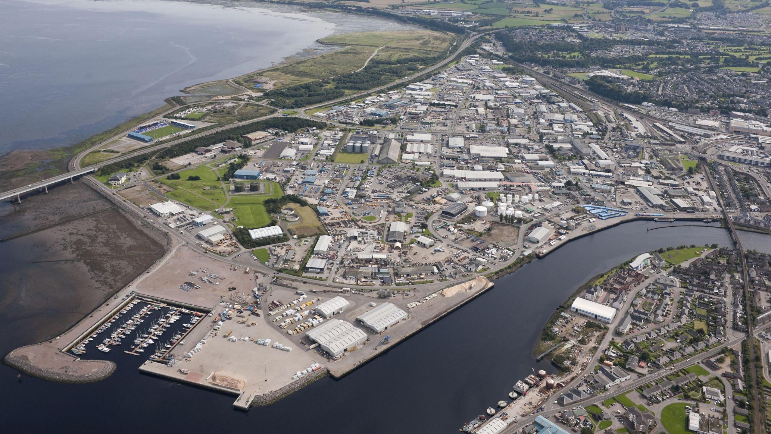 An aerial image showing the harbour, a marina with boats moored in it and a sprawling of industrial buildings in the Longman and Harbour Road areas of Inverness. 